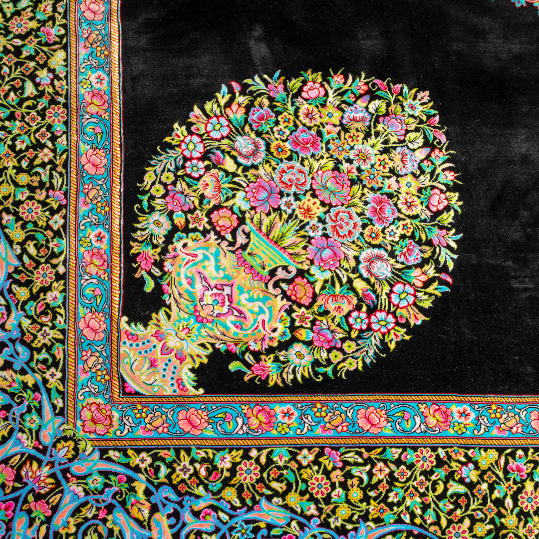 Luxurious silk rug featuring a central medallion in turquoise and pink, floral vases in corners, and ornate borders on a dark base.