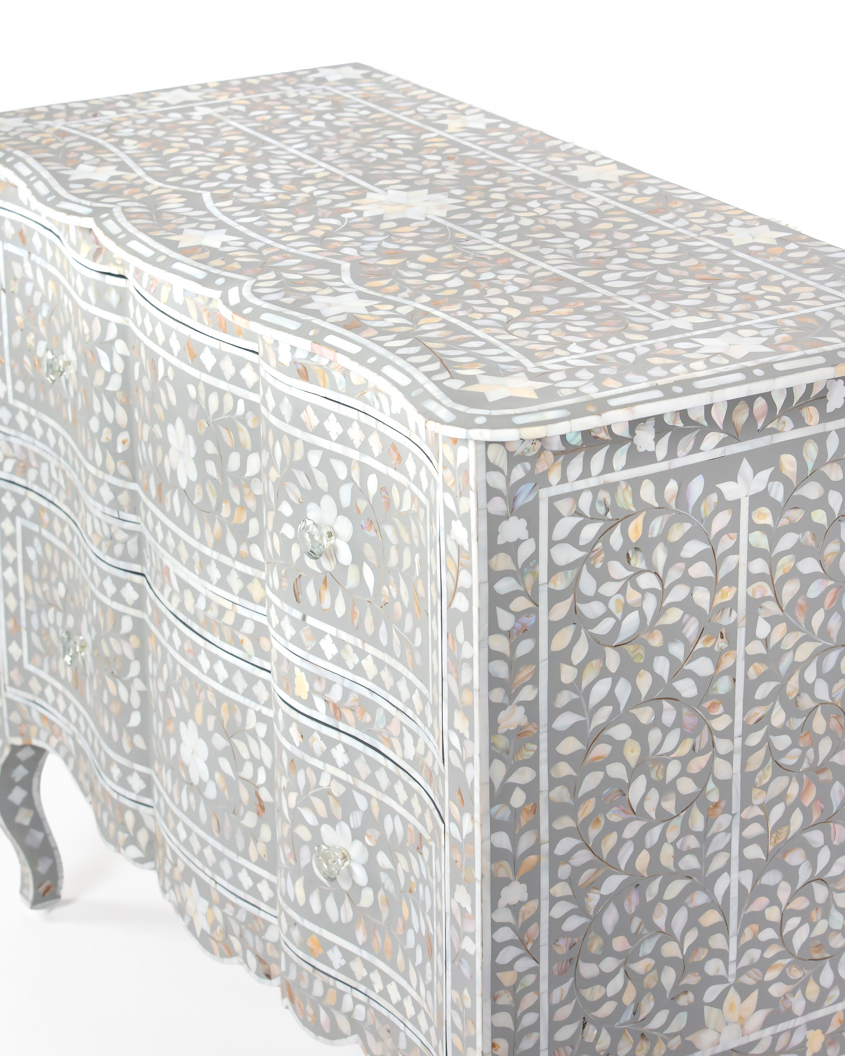 Top view of floral mother of pearl inlay pattern on grey chest of drawers