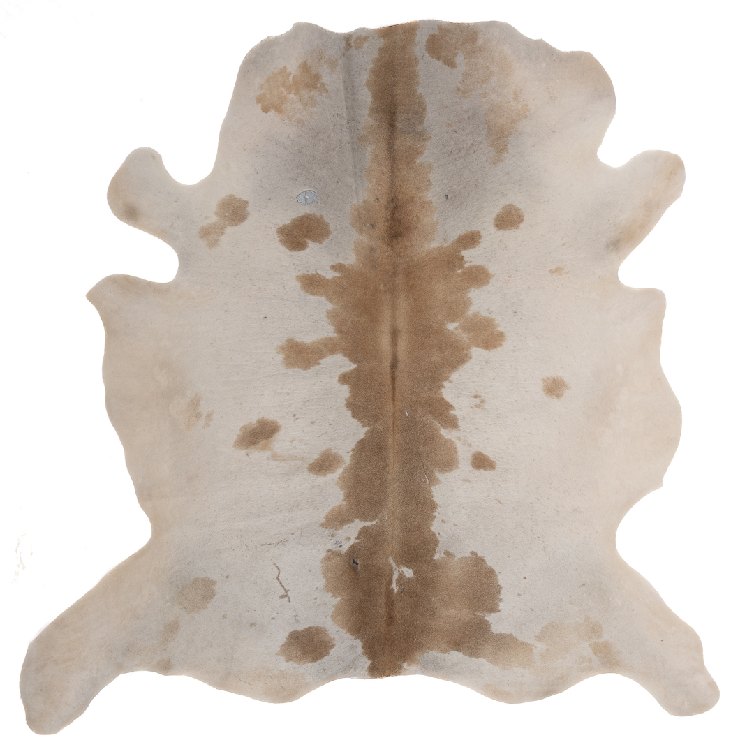 Natural cowhide rug with beige and chestnut brown markings, organic shape, and smooth textured finish.
