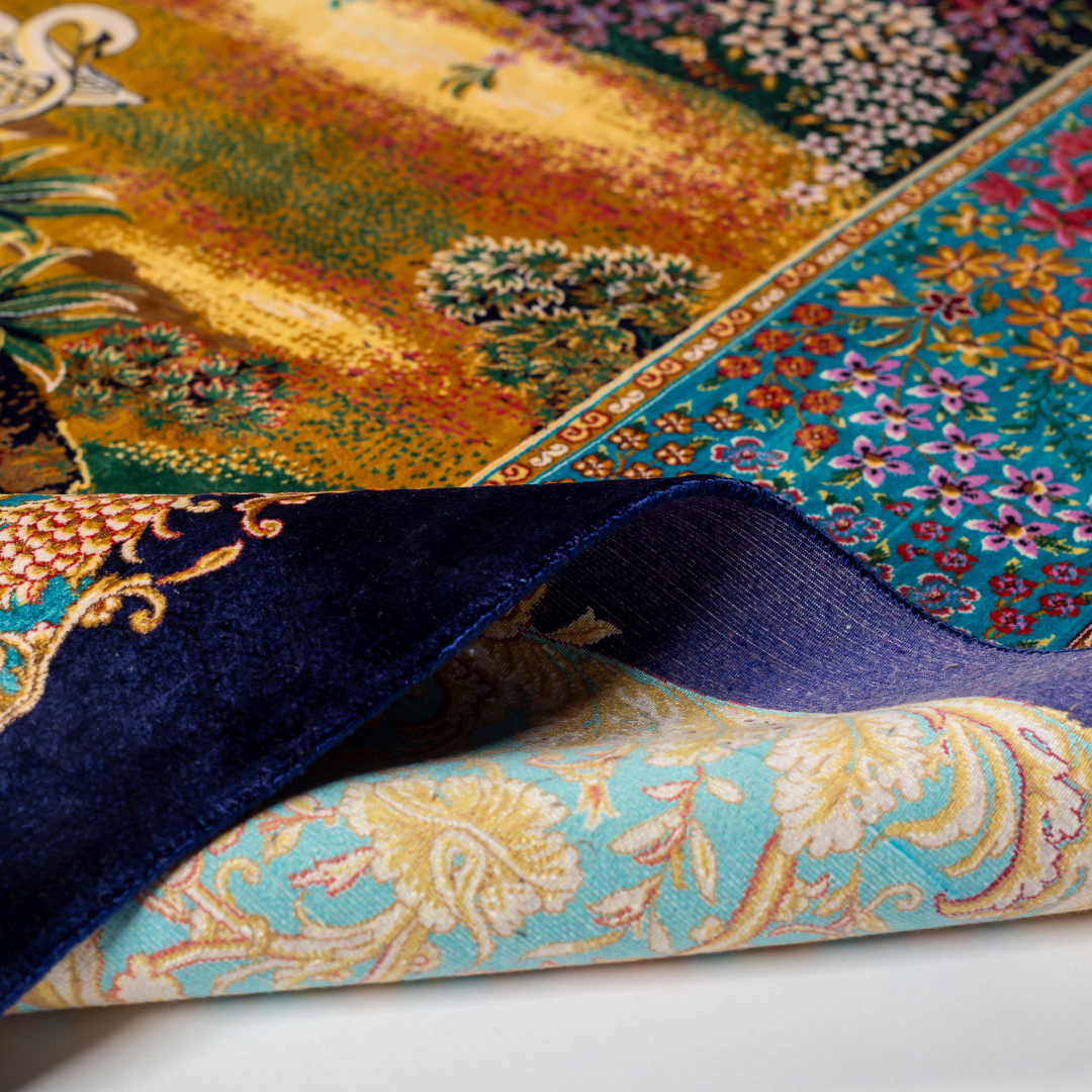 Elegant silk rug with flying birds and floral tree scene, bordered in ornate gold and blue. Handwoven with incredible detail and texture.