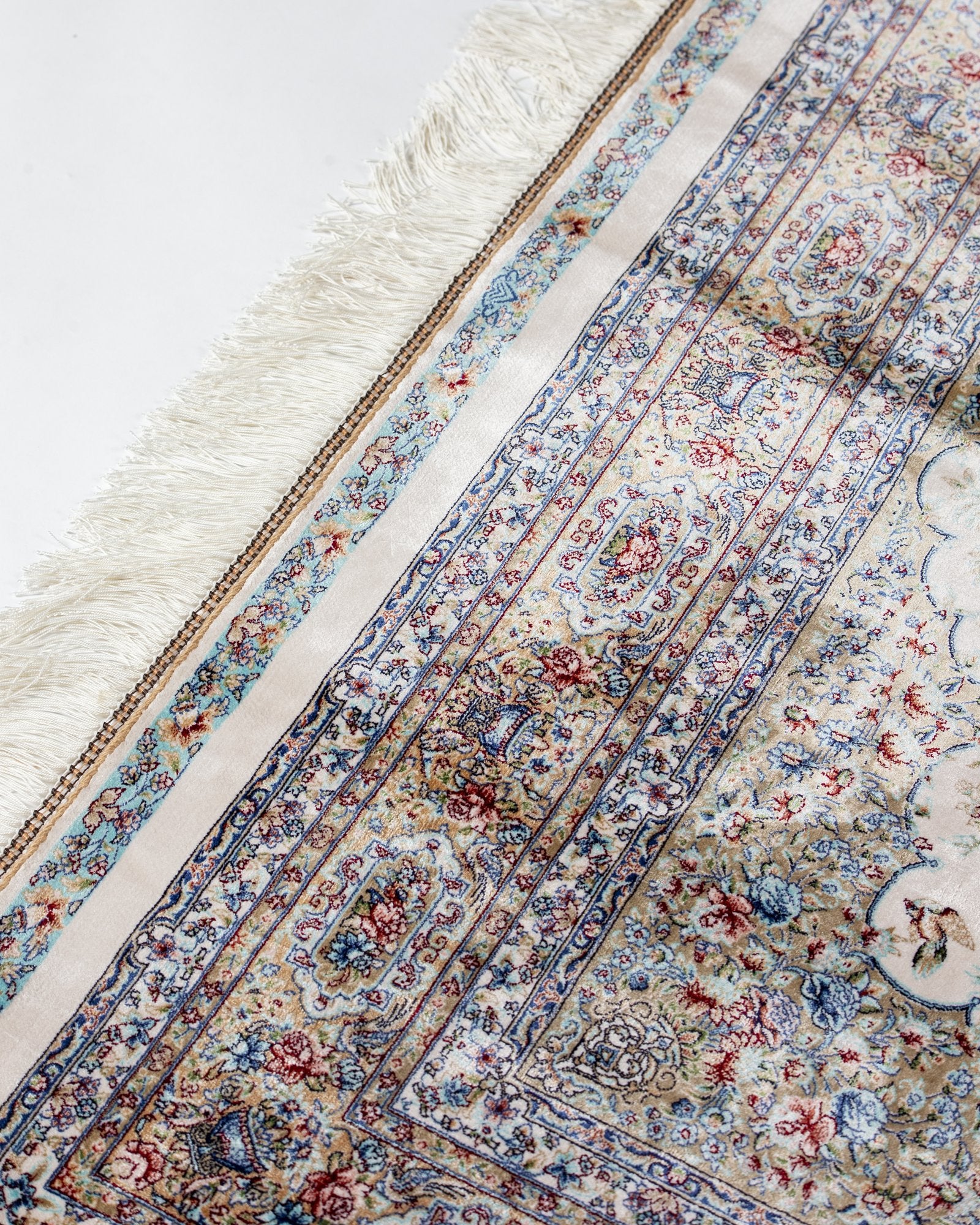 corner with silk fringe on the Parvaneh ivory silk rug