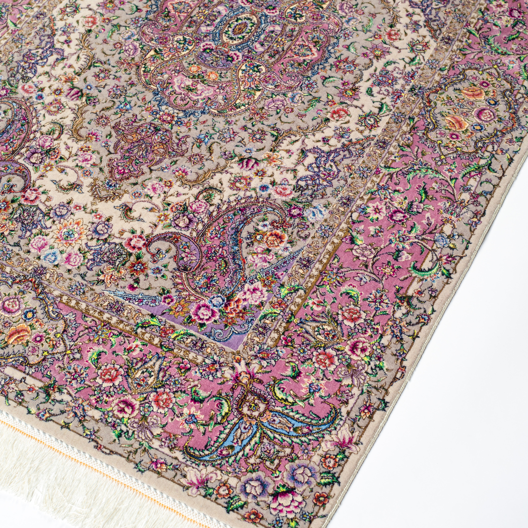 The Savina silk rug features a pink and beige floral medallion design, handwoven in fine silk with intricate detailing.