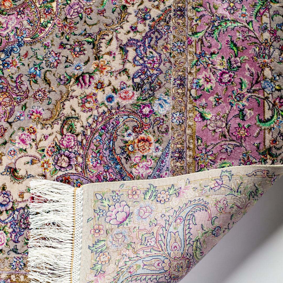 The Savina silk rug features a pink and beige floral medallion design, handwoven in fine silk with intricate detailing.