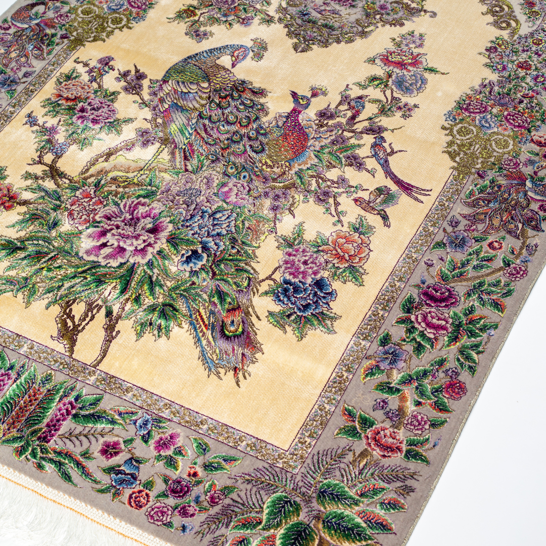 Luxurious ivory silk rug featuring peacocks, floral motifs, and intricate detailing, handcrafted with multicolored threads.
