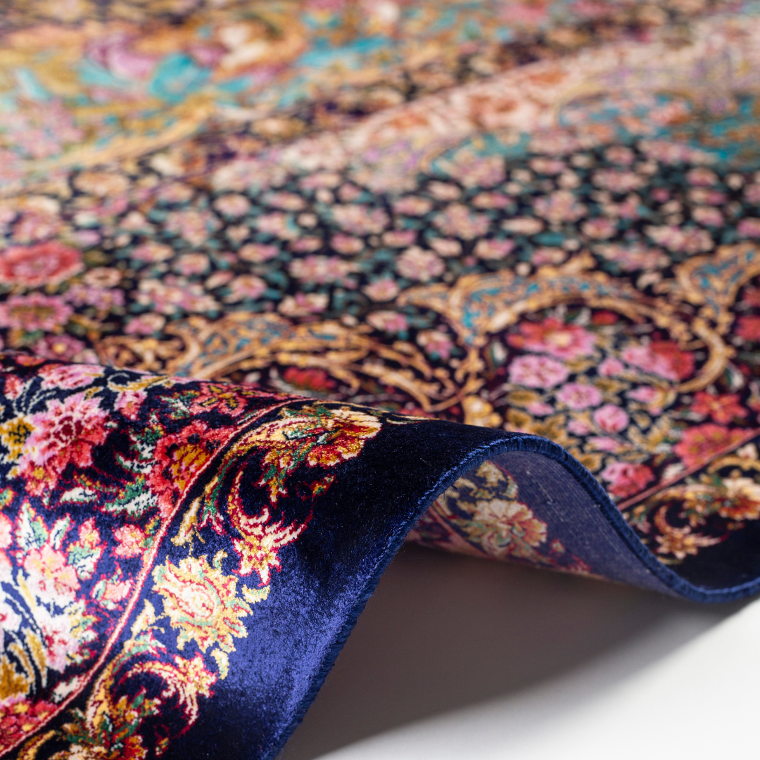 Elegant silk rug in navy, pink, gold, and turquoise with detailed Persian-inspired floral and dancer motifs.