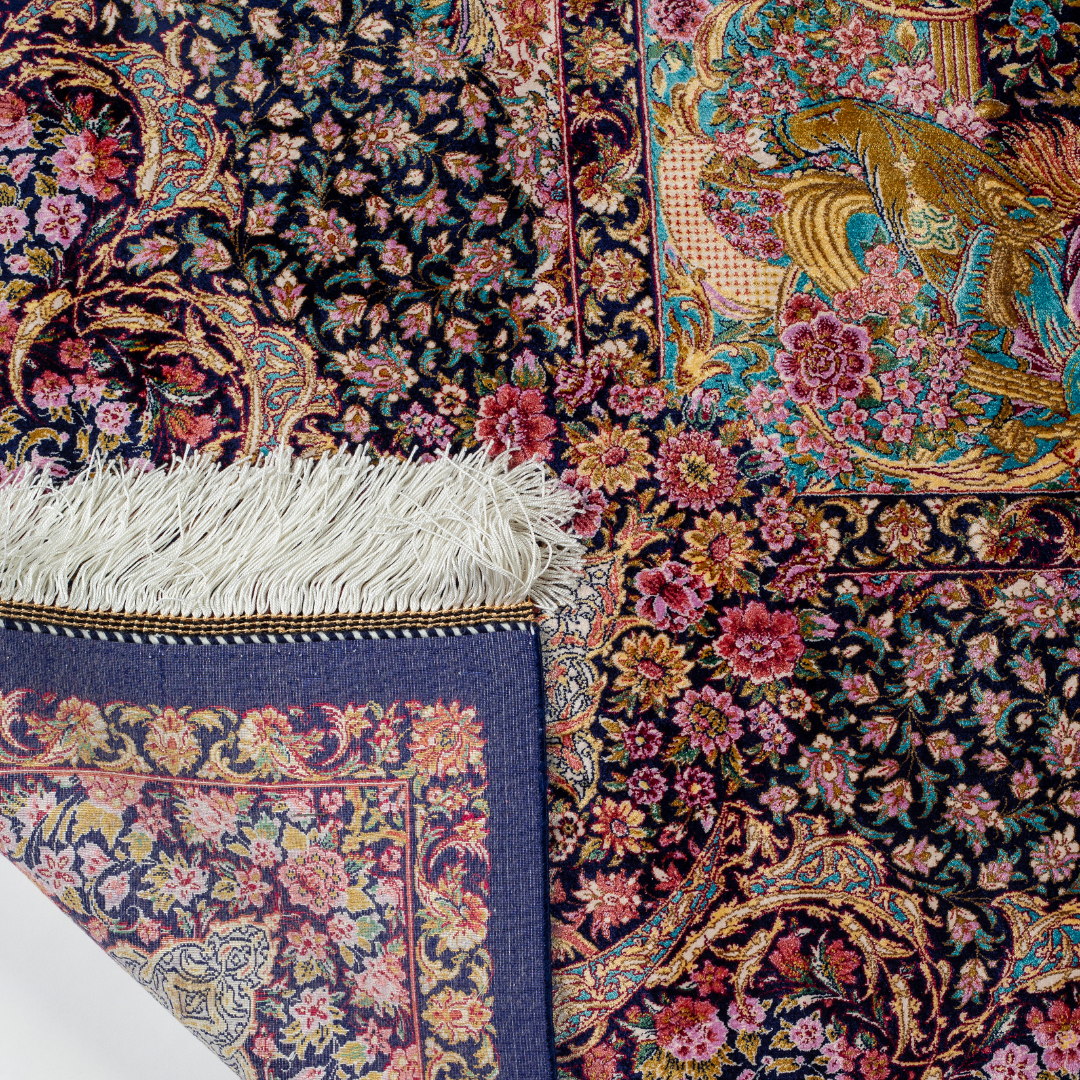 Elegant silk rug in navy, pink, gold, and turquoise with detailed Persian-inspired floral and dancer motifs.