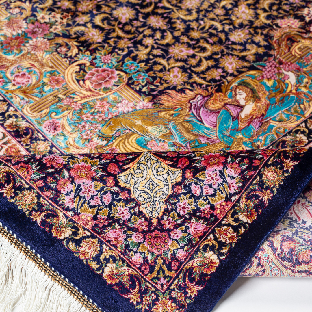Elegant silk rug in navy, pink, gold, and turquoise with detailed Persian-inspired floral and dancer motifs.
