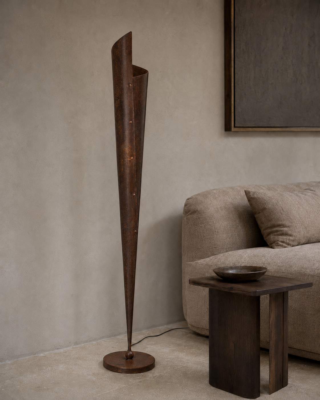 The Bonfire Floor Lamp by The Qratist features a handcrafted copper finished metal body with a sculptural tapered silhouette that emits a warm upward glow inspired by the timeless elegance of a bonfire.