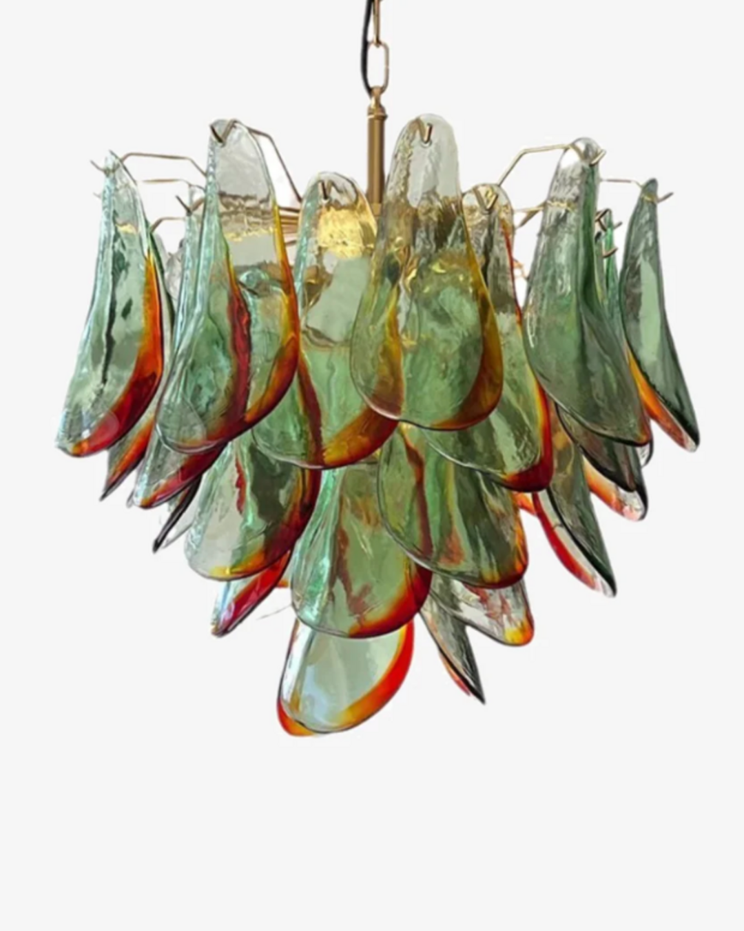 The Botanic Chandelier by The Qratist features handcrafted green and amber glass leaves layered around a refined metal frame, creating a sculptural botanical statement inspired by nature.