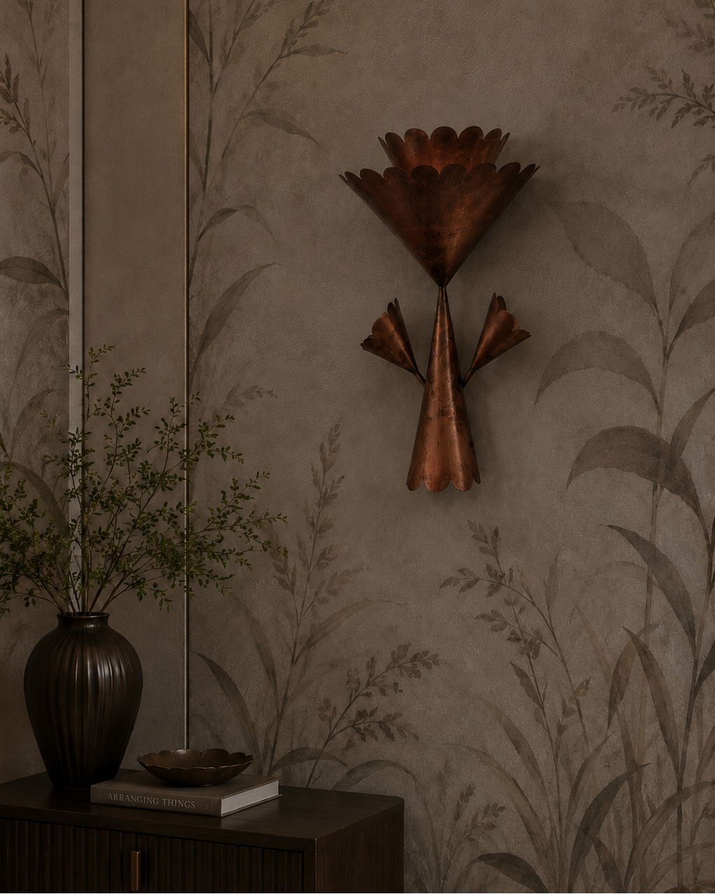 The Corsage Wall Light by The Qratist features handcrafted copper finished metal petals arranged in a sculptural floral composition that creates warm ambient illumination.
