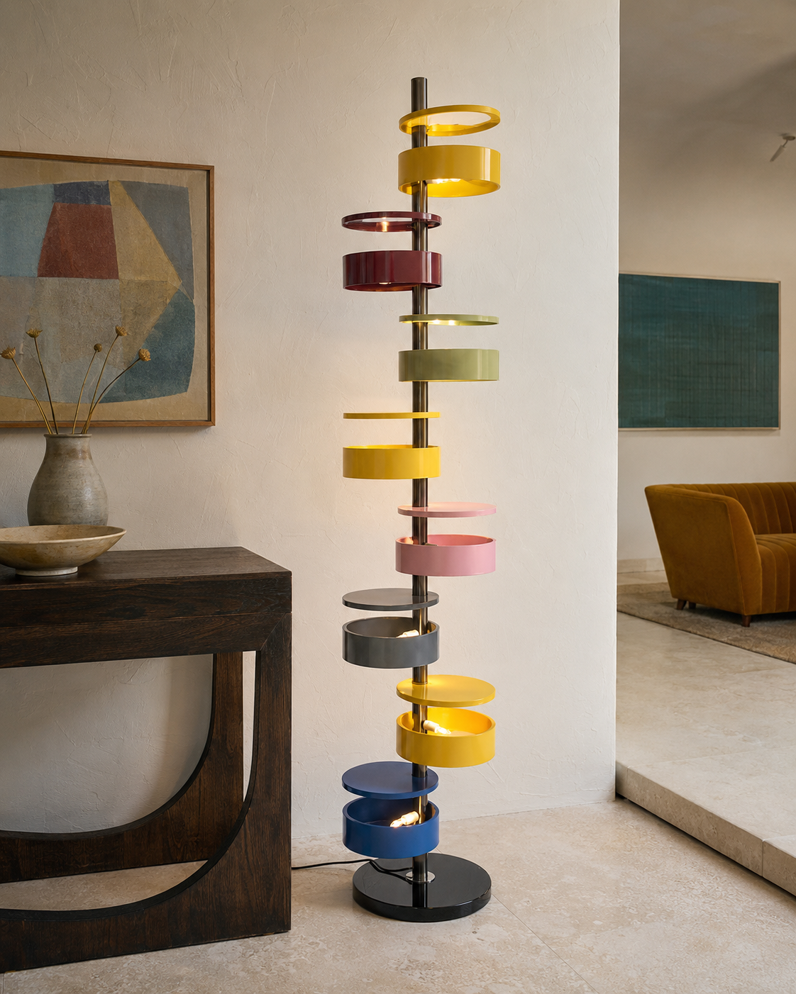 The Crayon Floor Lamp by The Qratist features colourful sculptural metal rings spiralling around a polished central column with a solid marble base, creating a playful contemporary floor lighting statement.