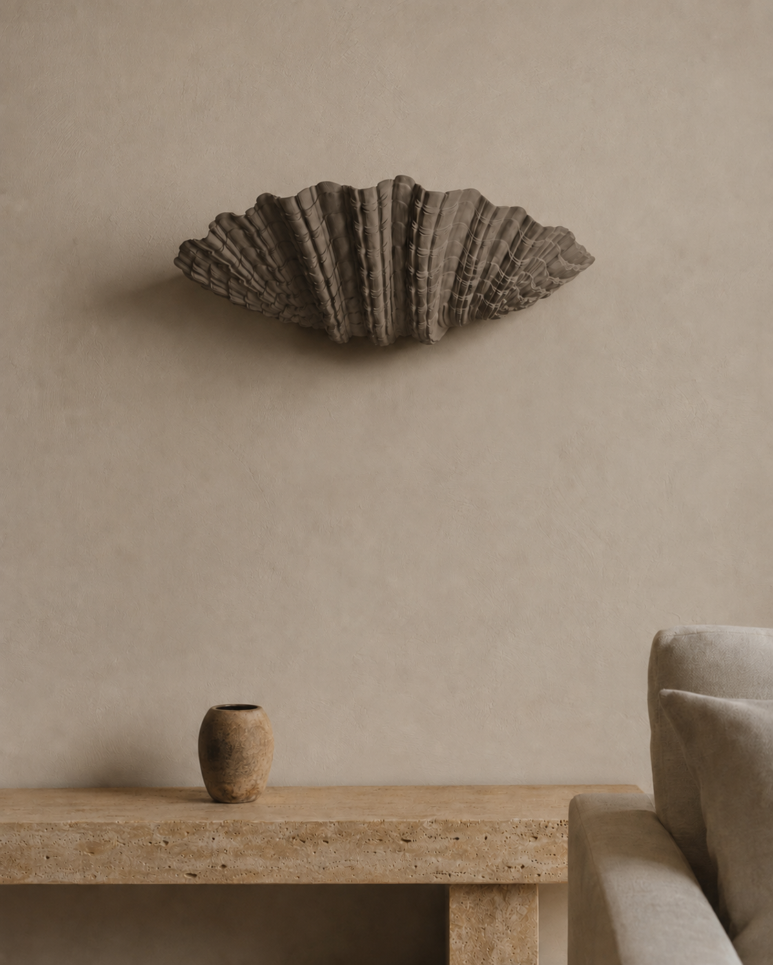 The Grotto Wall Light by The Qratist features a handcrafted sculptural form inspired by coastal grottos, crafted from plaster, polyresin, and sandstone to create warm ambient illumination.