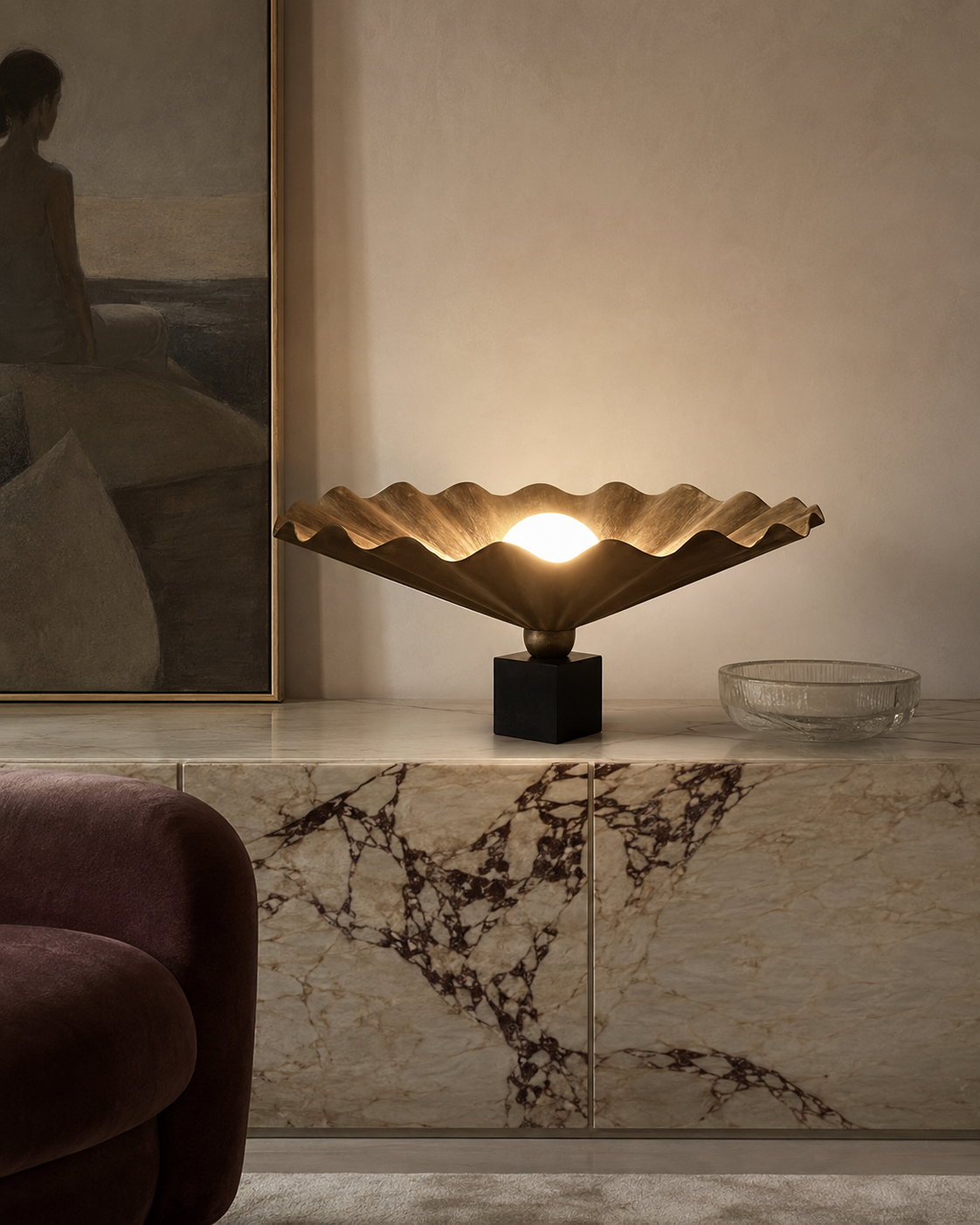 The King Table Oyster Lamp by The Qratist features a handcrafted matt bronze metal form with a sculptural paper diffuser surrounding a glowing central light, creating a refined organic statement table lamp.