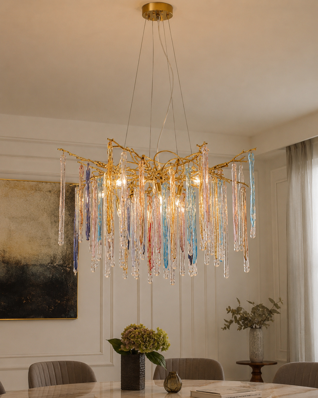 The Kryptonite Chandelier by The Qratist features handcrafted glass rods suspended from an organic brass framework, creating a bold sculptural statement inspired by crystalline formations.