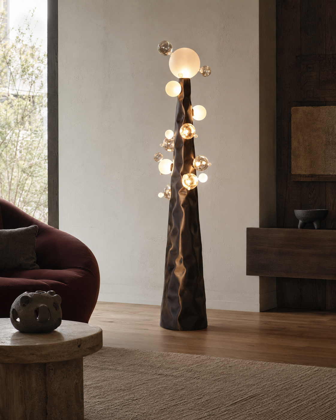 The Molecular Floor Lamp by The Qratist features a sculptural matte bronze steel column surrounded by handcrafted blown glass spheres, creating a striking molecular inspired floor lamp with warm ambient illumination.