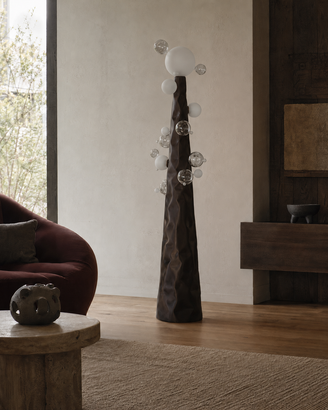 The Molecular Floor Lamp by The Qratist features a sculptural matte bronze steel column surrounded by handcrafted blown glass spheres, creating a striking molecular inspired floor lamp with warm ambient illumination.