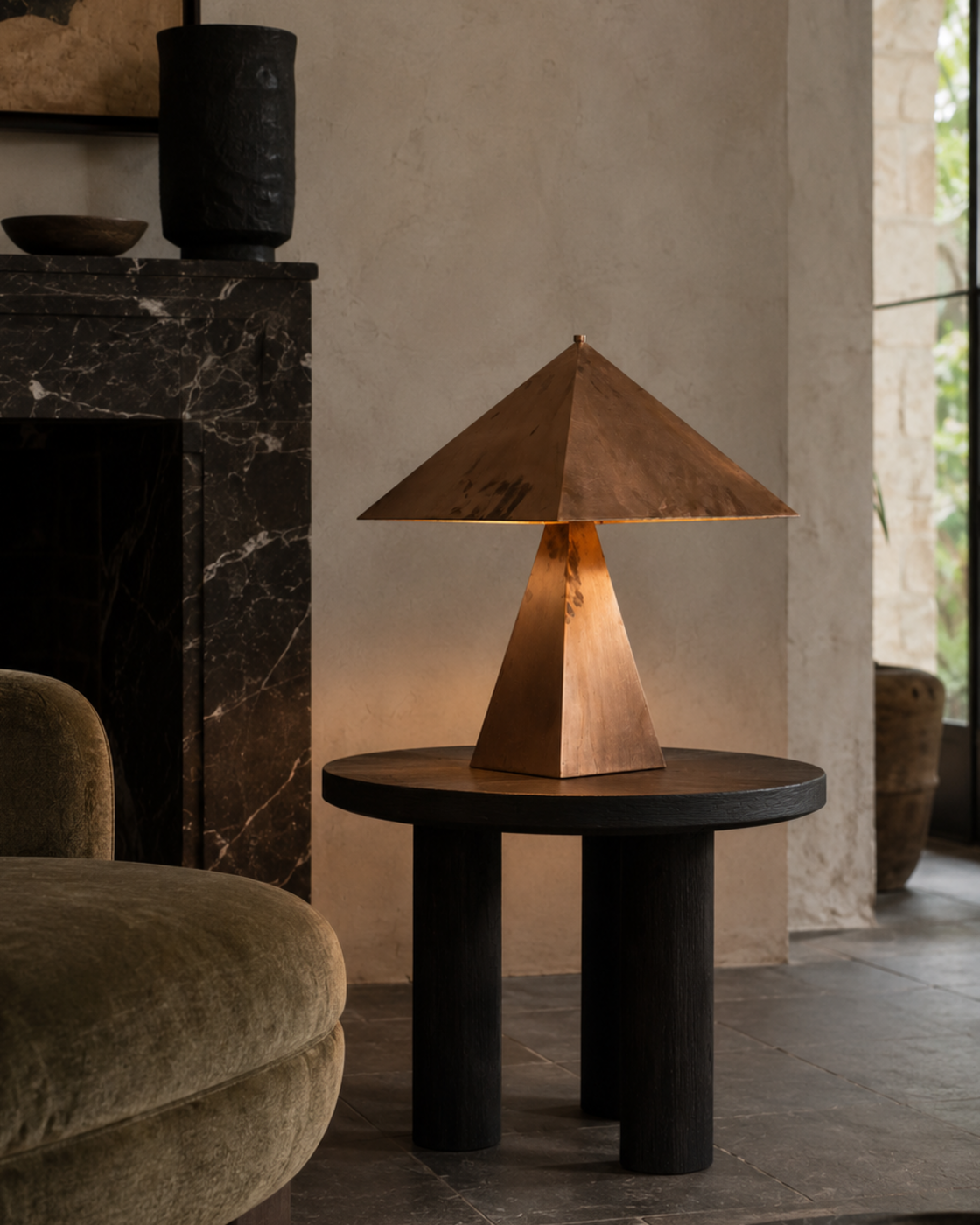 The Oriental Table Lamp by The Qratist features a handcrafted solid copper pyramidal shade and tapered geometric base, creating a timeless sculptural table lamp with warm ambient illumination.