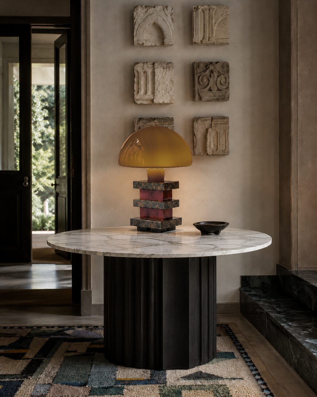 The Pagoda Table Lamp by The Qratist features a handcrafted amber blown glass dome balanced above sculptural glass columns and layered granite accents, creating a luxurious architectural statement table lamp.