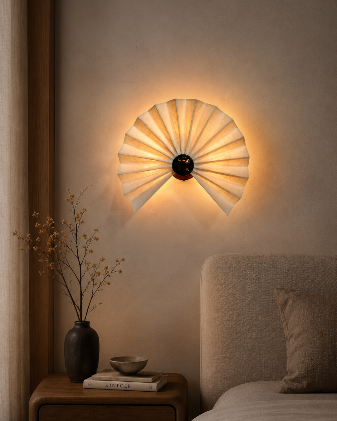 The Sensu Wall Light by The Qratist features handcrafted folded paper panels and a metal frame inspired by the traditional Japanese sensu fan, creating warm ambient illumination.