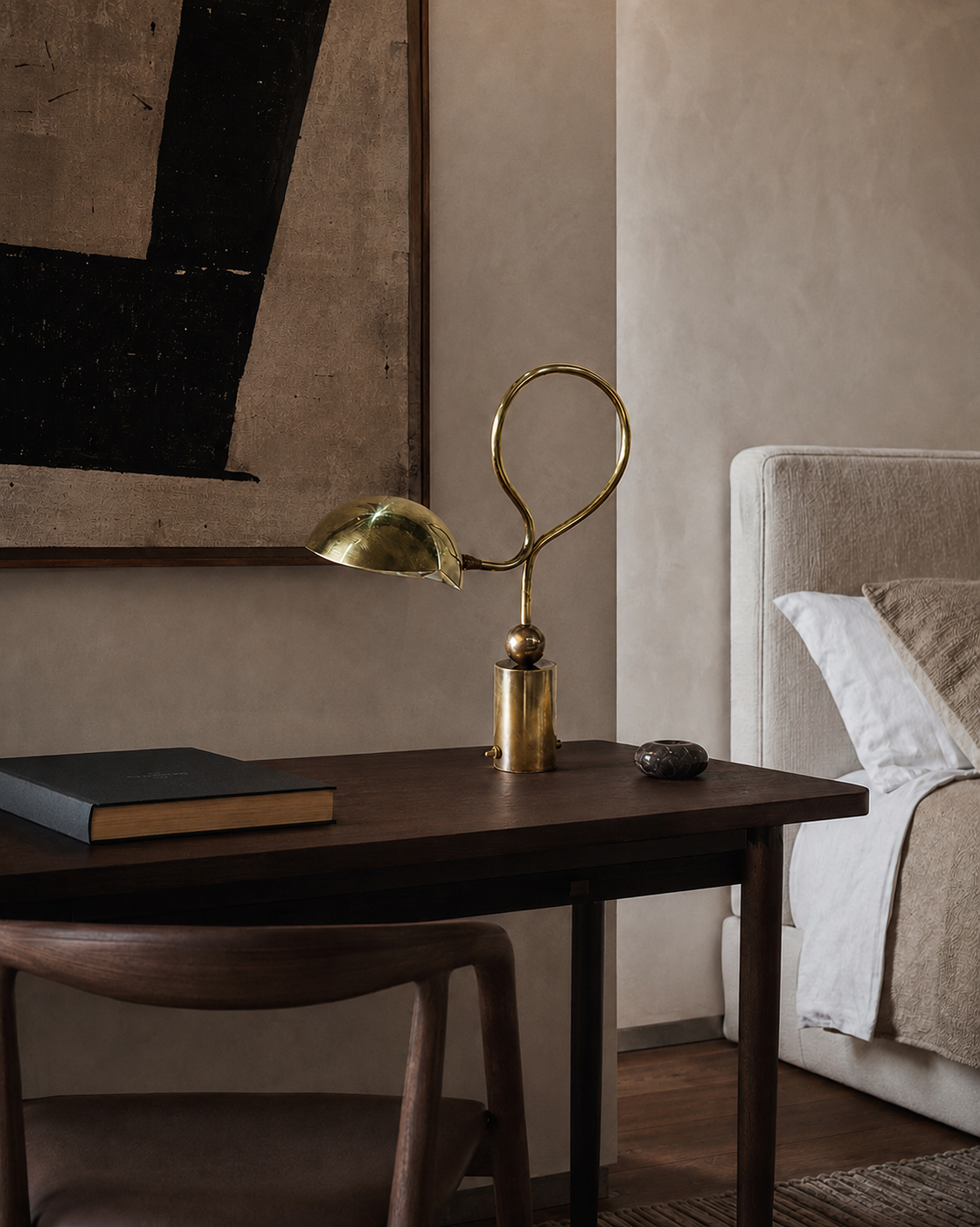 The Serpenti Table Lamp by The Qratist features a handcrafted solid brass looping frame with an adjustable dome shade, creating a sculptural table lamp with elegant warm ambient illumination.