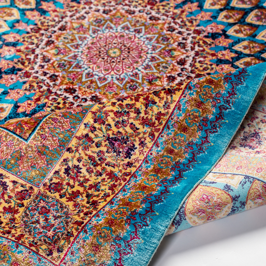 Verta silk rug featuring a turquoise blue base with intricate gold, ruby red, ivory, and fuchsia floral medallion design in a symmetrical pattern.