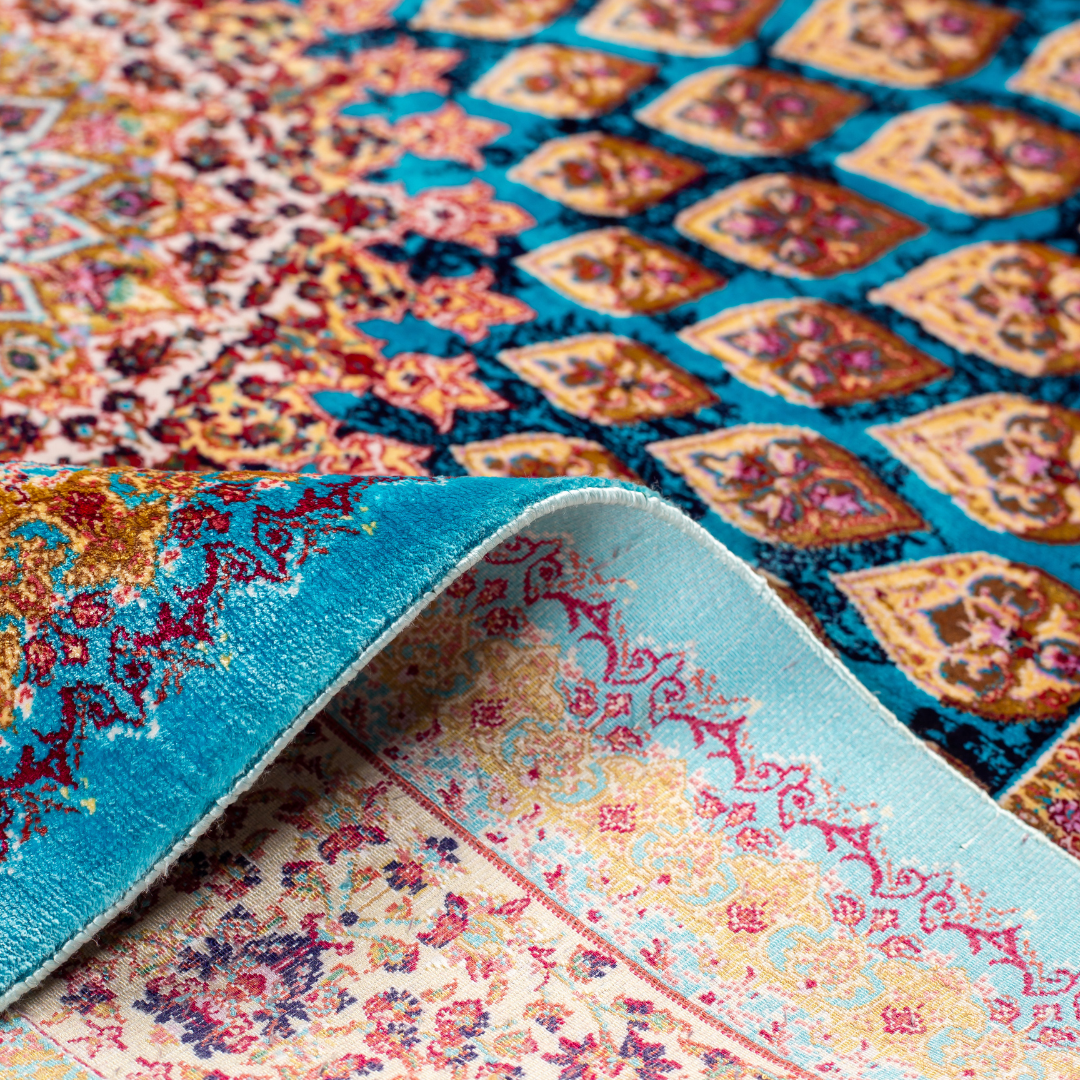 Verta silk rug featuring a turquoise blue base with intricate gold, ruby red, ivory, and fuchsia floral medallion design in a symmetrical pattern.