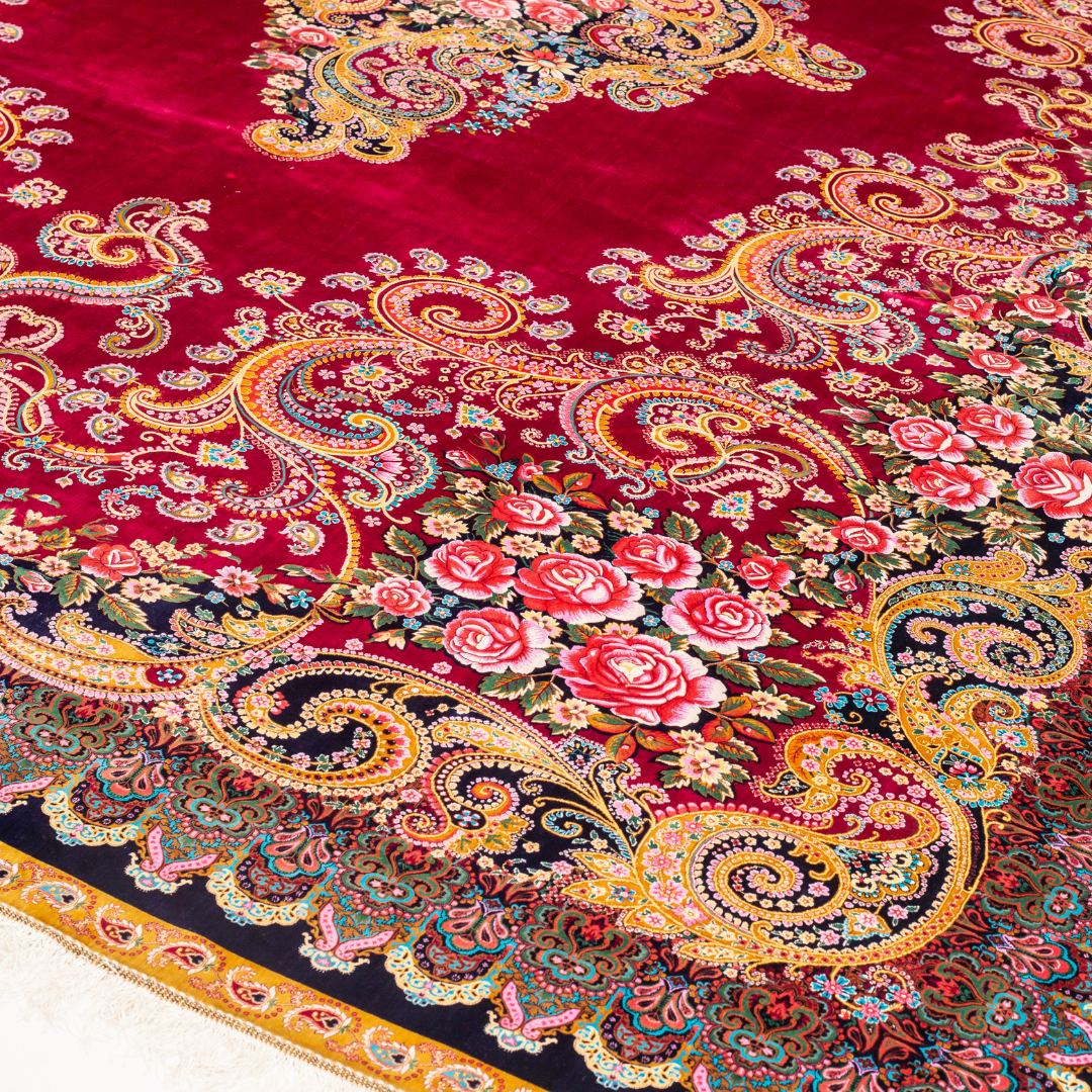 Zinia Silk Rug with crimson red base, floral medallion pattern, intricate gold scrolls, and a navy border, crafted in fine silk with detailed motifs.