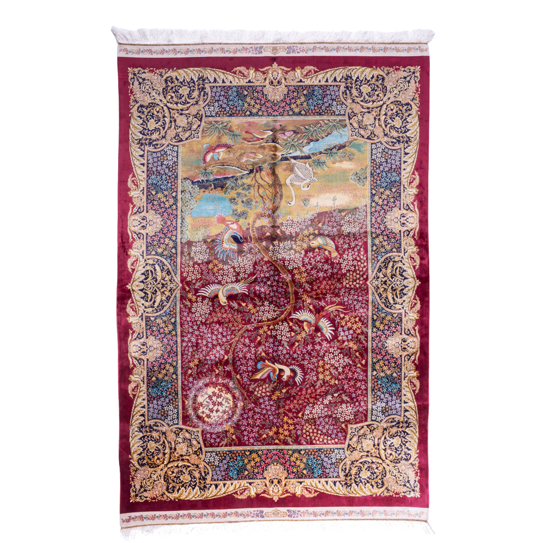 Silk rug with tree of life and bird motif, burgundy floral base, and ornate navy-gold borders. Handwoven with artistic precision.