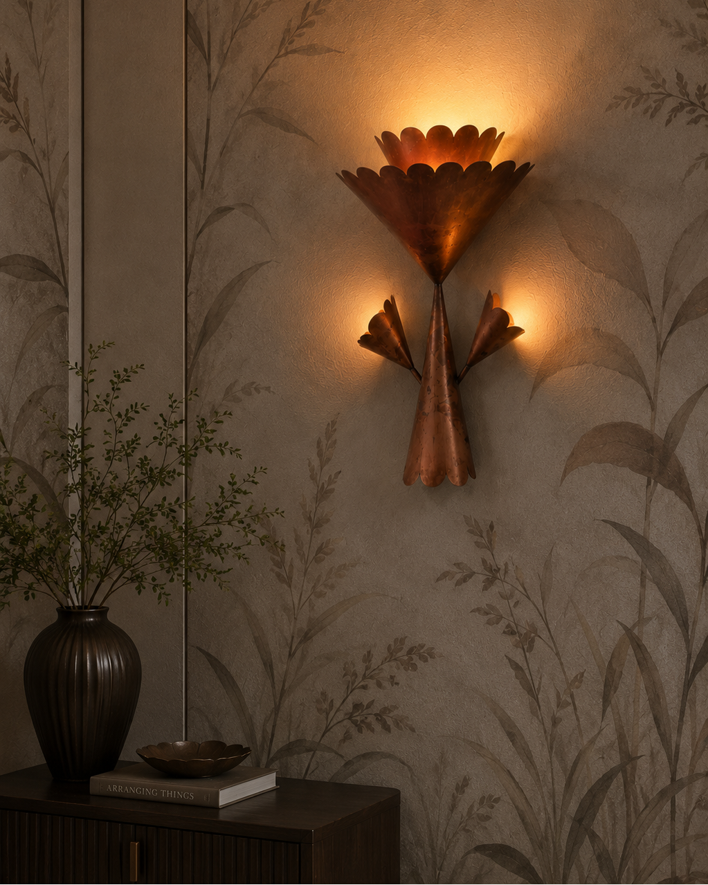 The Corsage Wall Light by The Qratist features handcrafted copper finished metal petals arranged in a sculptural floral composition that creates warm ambient illumination.
