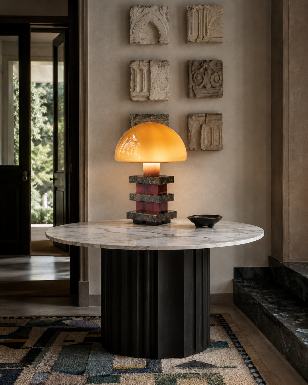 The Pagoda Lamp by The Qratist features a handcrafted amber blown glass dome balanced above sculptural glass columns and layered granite accents, creating a luxurious architectural statement table lamp.