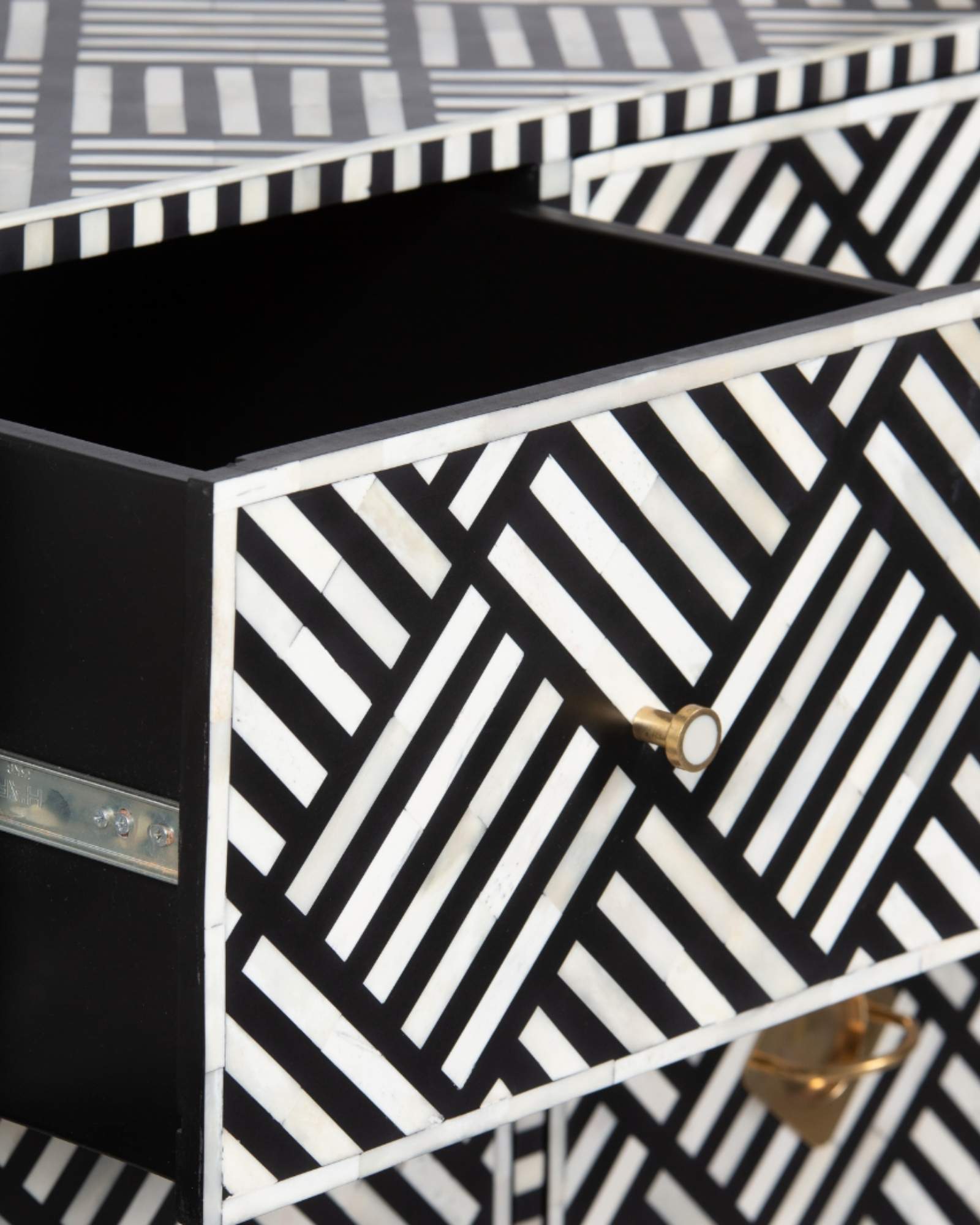 Luxury black and white bone inlay chest of drawers with brass accents and geometric design, handcrafted for statement interiors.