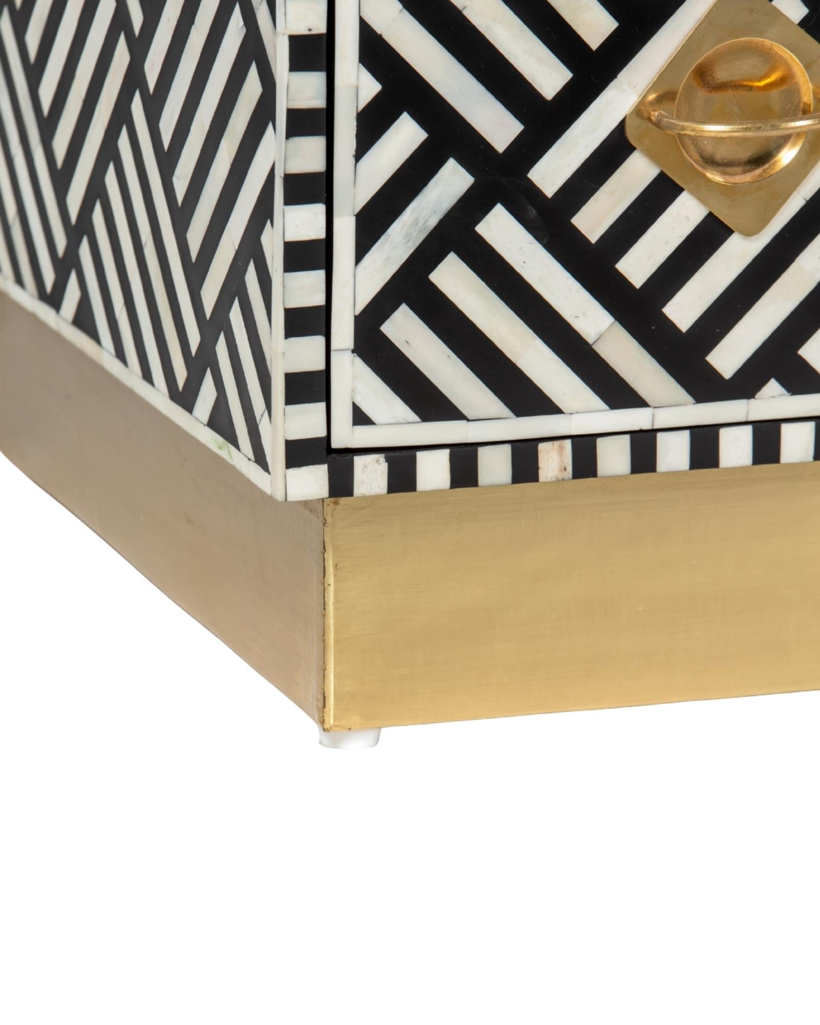 Luxury black and white bone inlay chest of drawers with brass accents and geometric design, handcrafted for statement interiors.