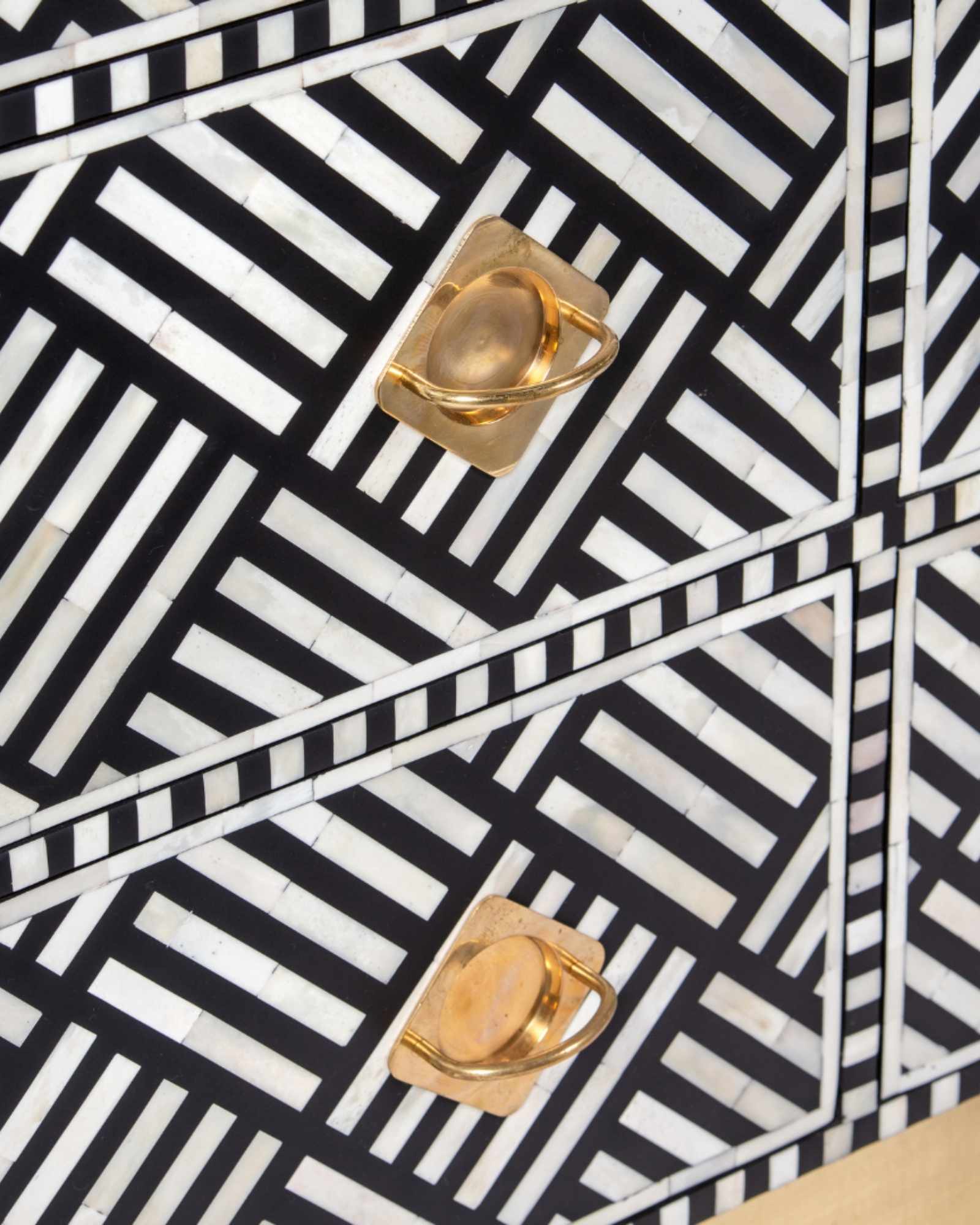 Luxury black and white bone inlay chest of drawers with brass accents and geometric design, handcrafted for statement interiors.