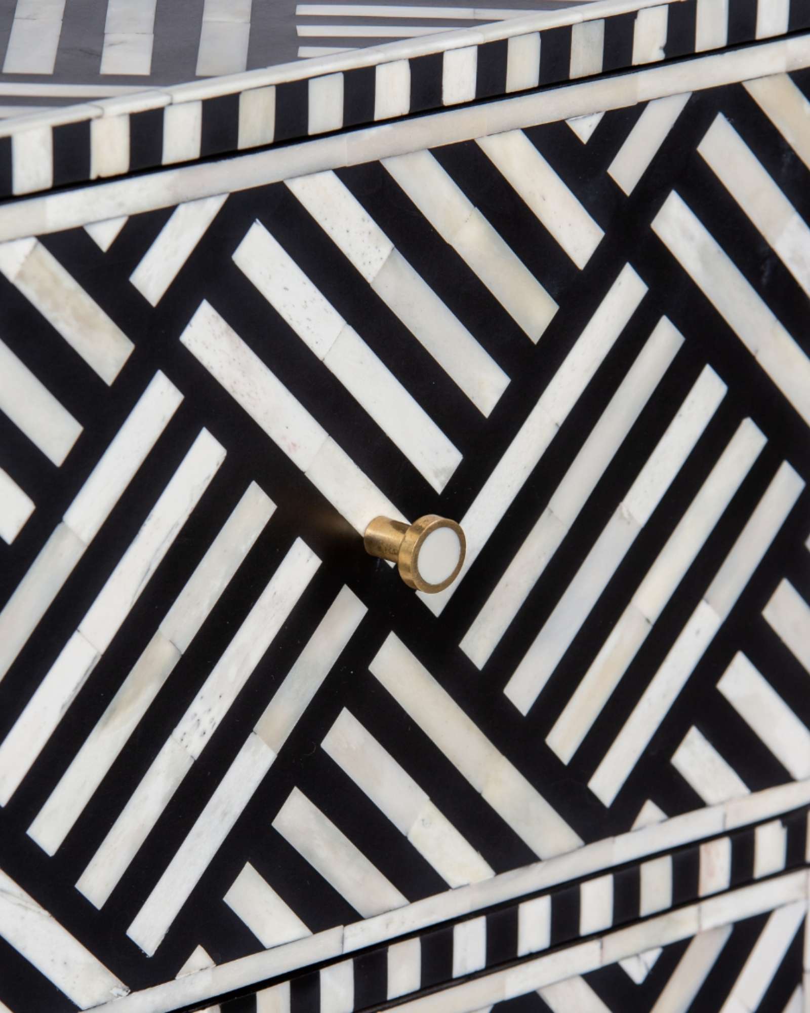 Luxury black and white bone inlay chest of drawers with brass accents and geometric design, handcrafted for statement interiors.