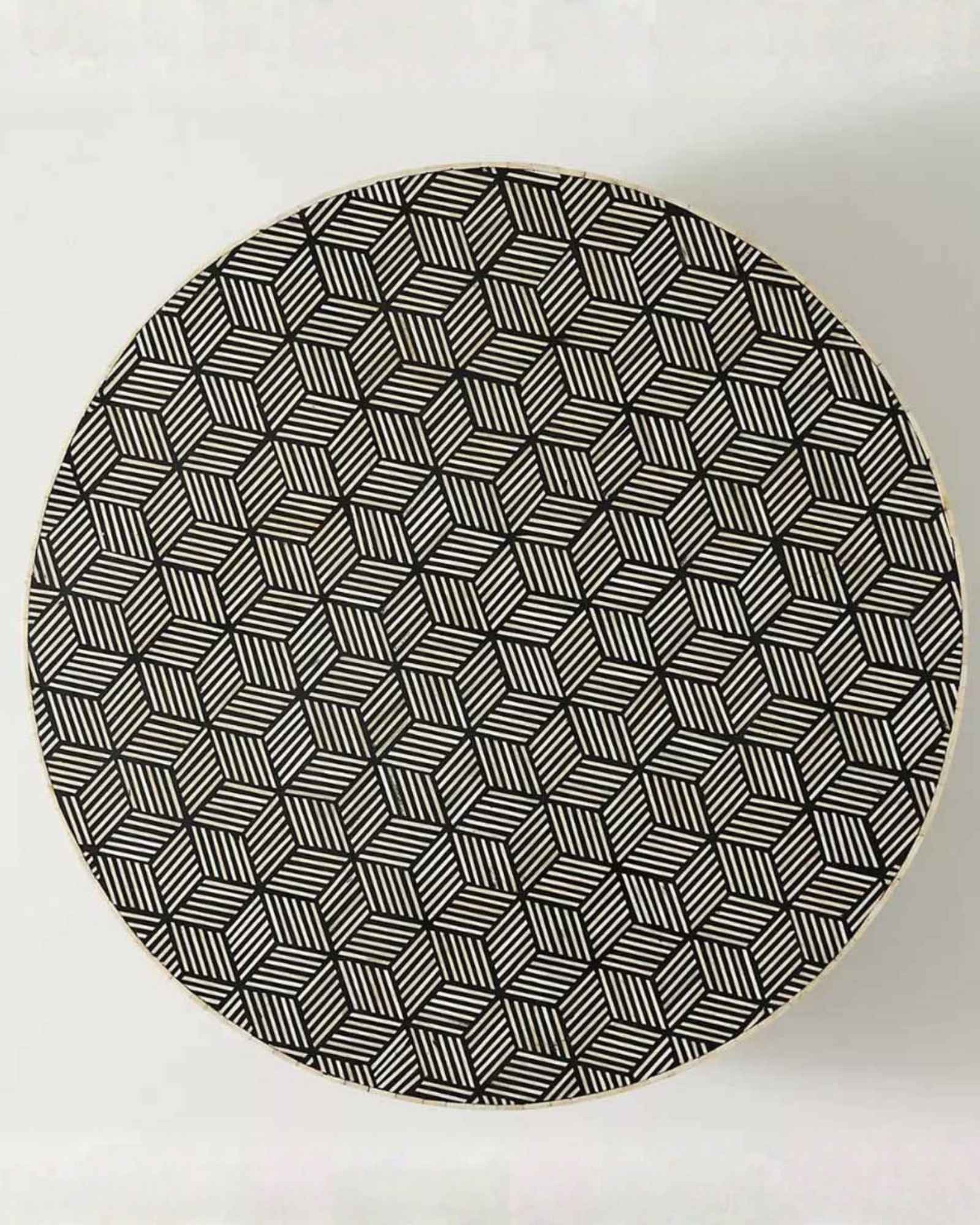 Round black bone inlay coffee table with a bold geometric pattern and gold base. A modern centerpiece for elegant living spaces.