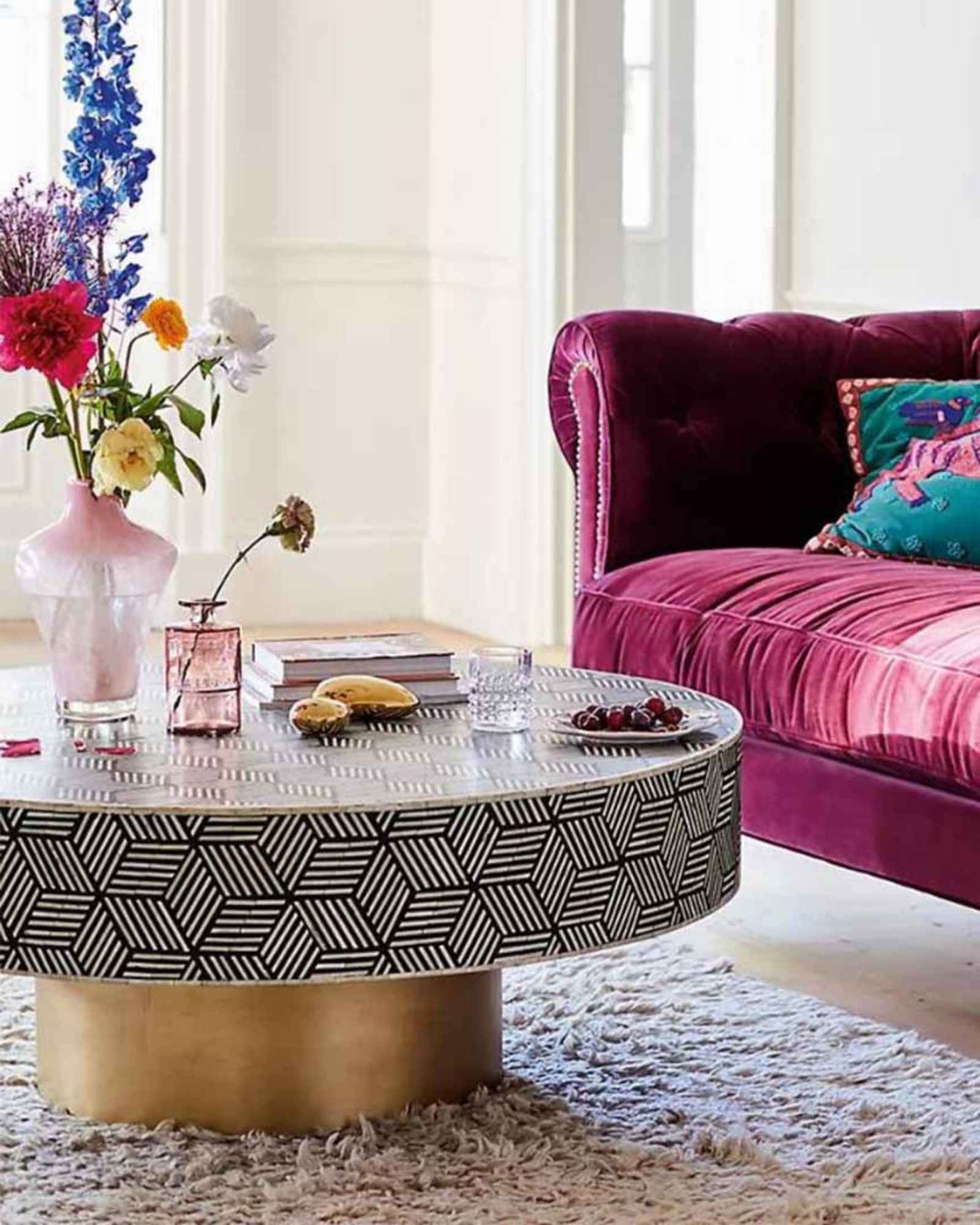 Round black bone inlay coffee table with a bold geometric pattern and gold base. A modern centerpiece for elegant living spaces.