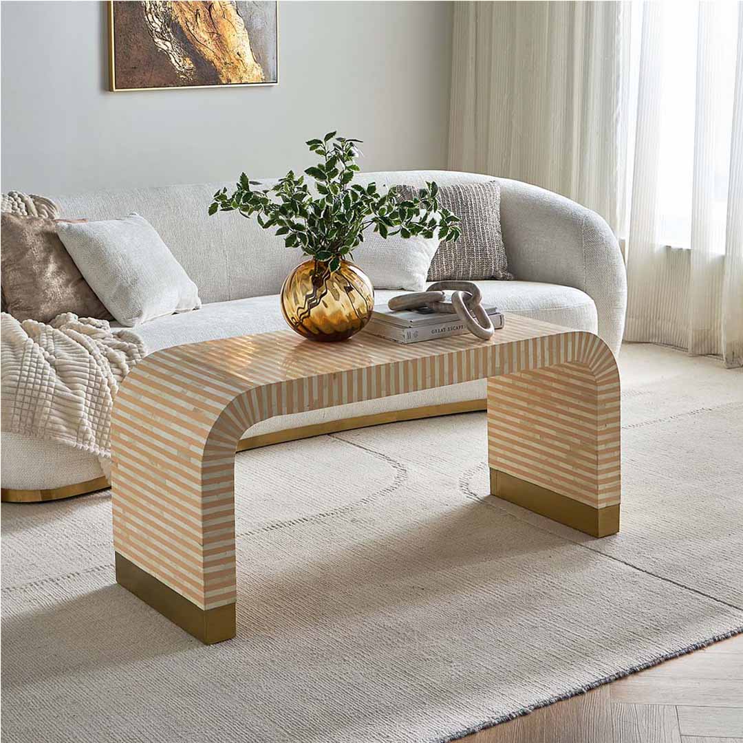 Modern beige bone inlay coffee table with curved edges and gold base. Features a striped inlay design for an elegant aesthetic.