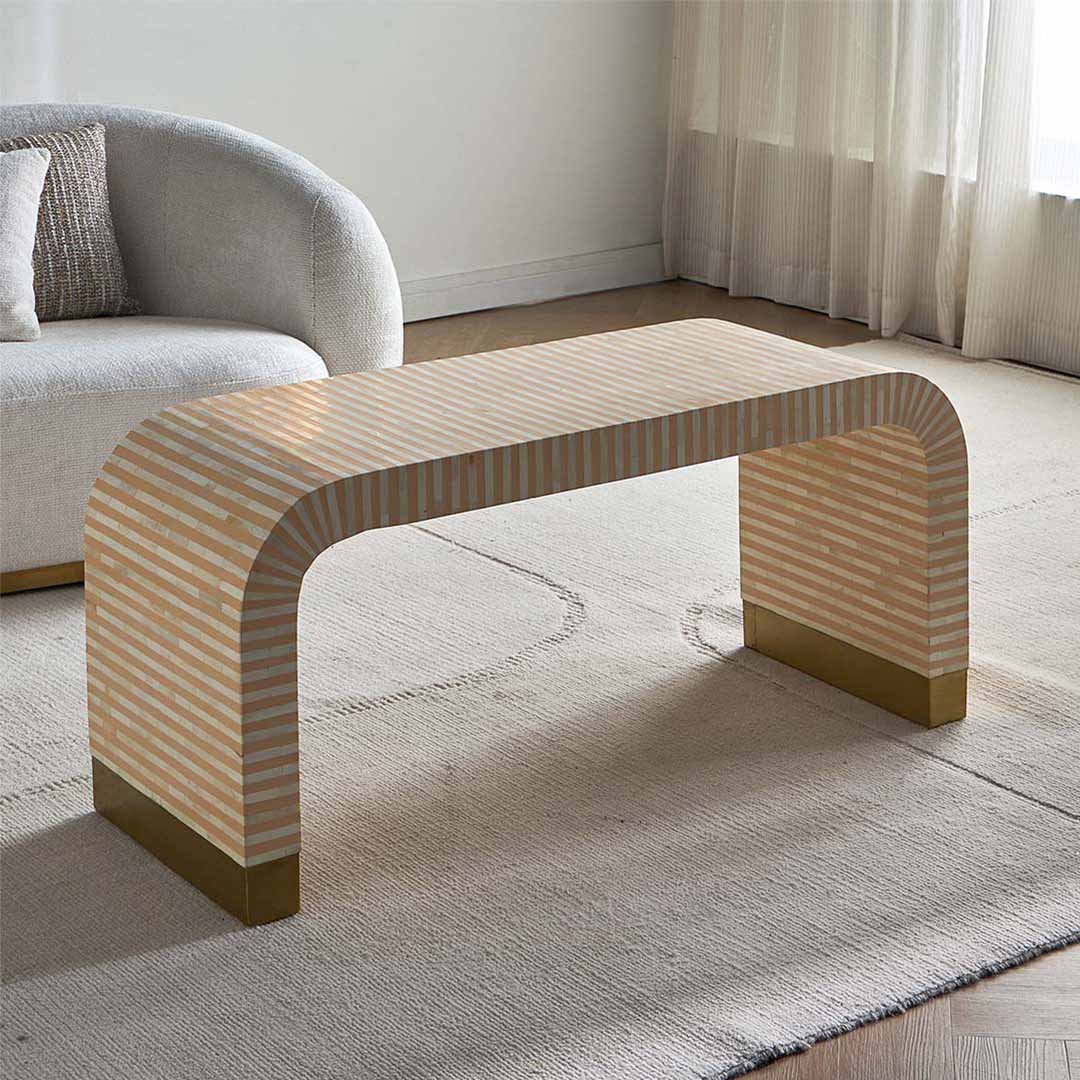 Modern beige bone inlay coffee table with curved edges and gold base. Features a striped inlay design for an elegant aesthetic.