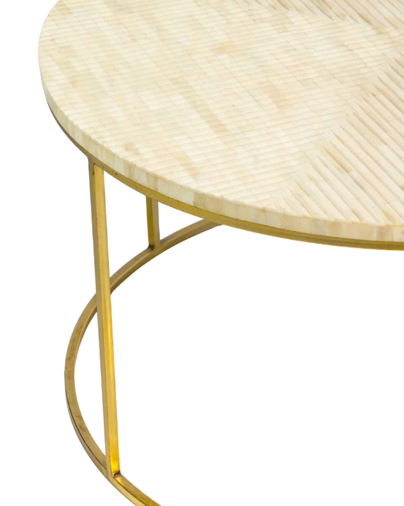 Ivory bone carved coffee table with linear textured pattern and gold metal circular frame by Tabeer Homes.