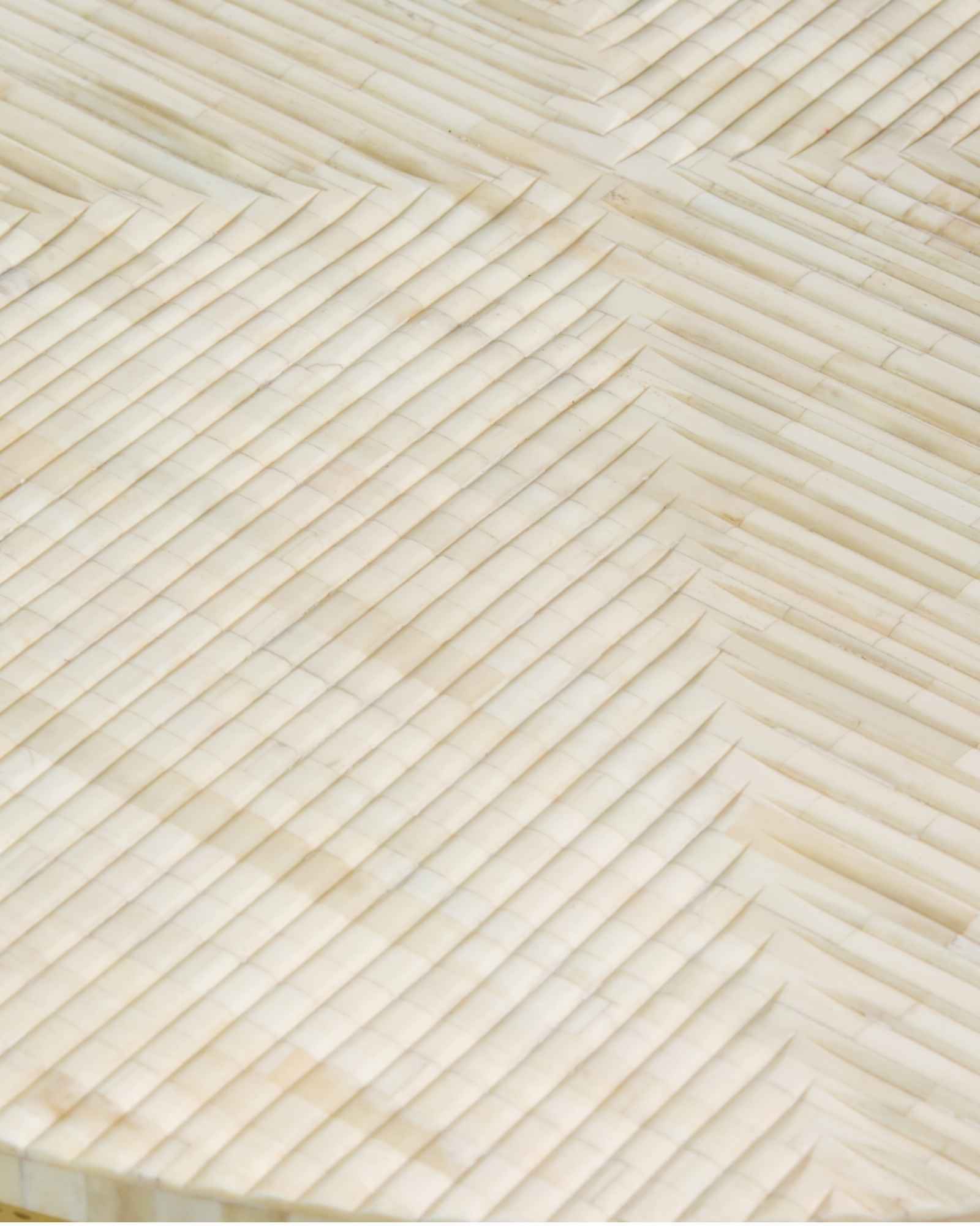 Ivory bone carved coffee table with linear textured pattern and gold metal circular frame by Tabeer Homes.