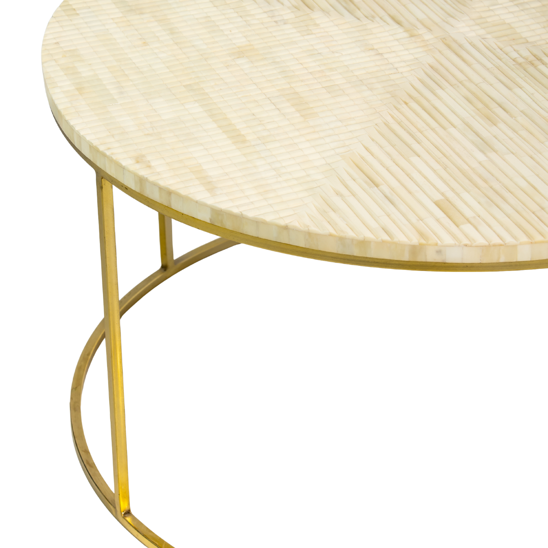 Ivory bone carved coffee table with linear textured pattern and gold metal circular frame by Tabeer Homes.
