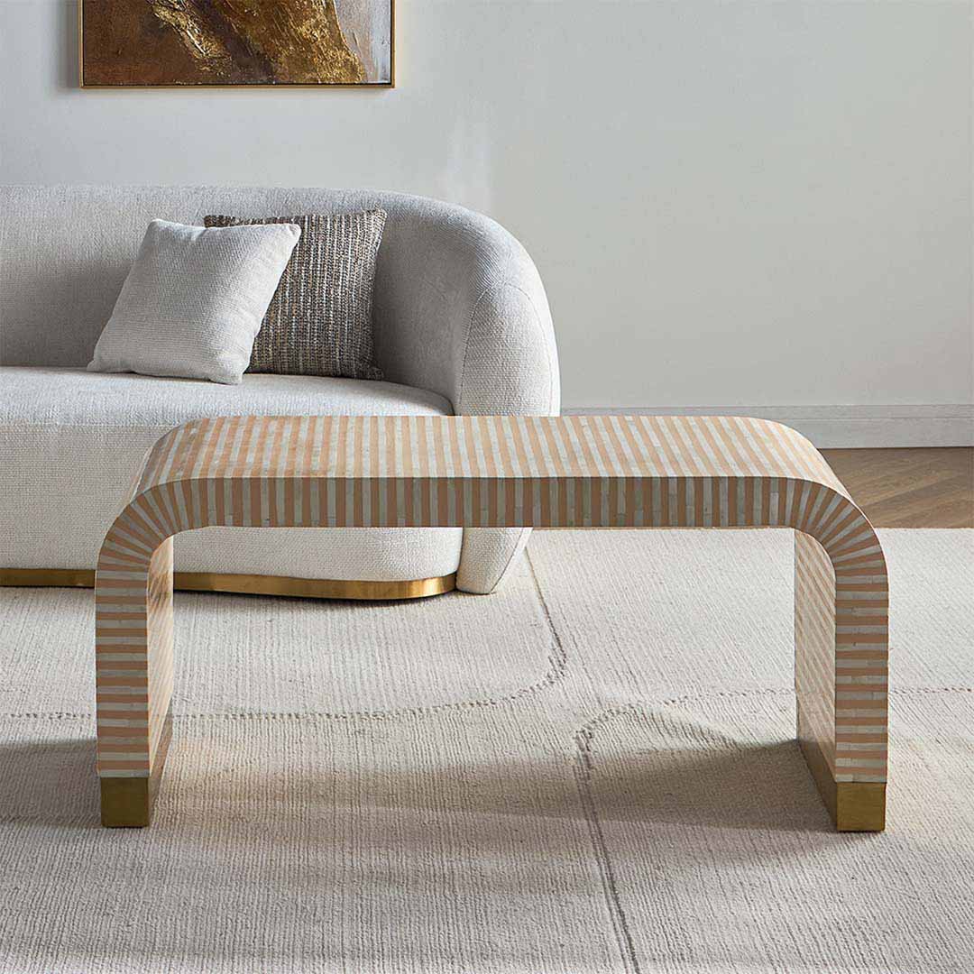 Modern beige bone inlay coffee table with curved edges and gold base. Features a striped inlay design for an elegant aesthetic.