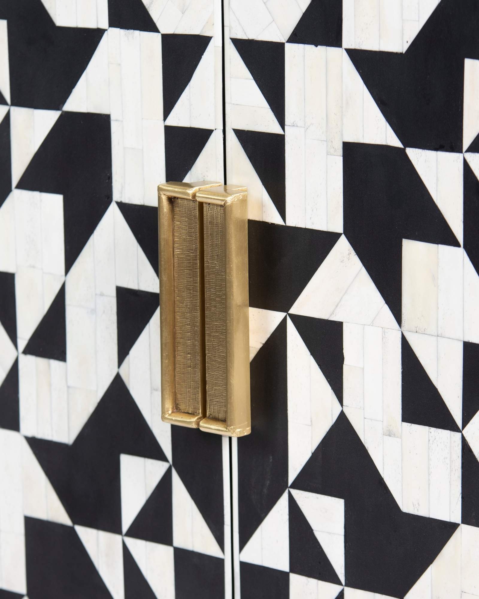Bone inlay cabinet featuring geometric pattern in black and white with metal base, handcrafted furniture piece.