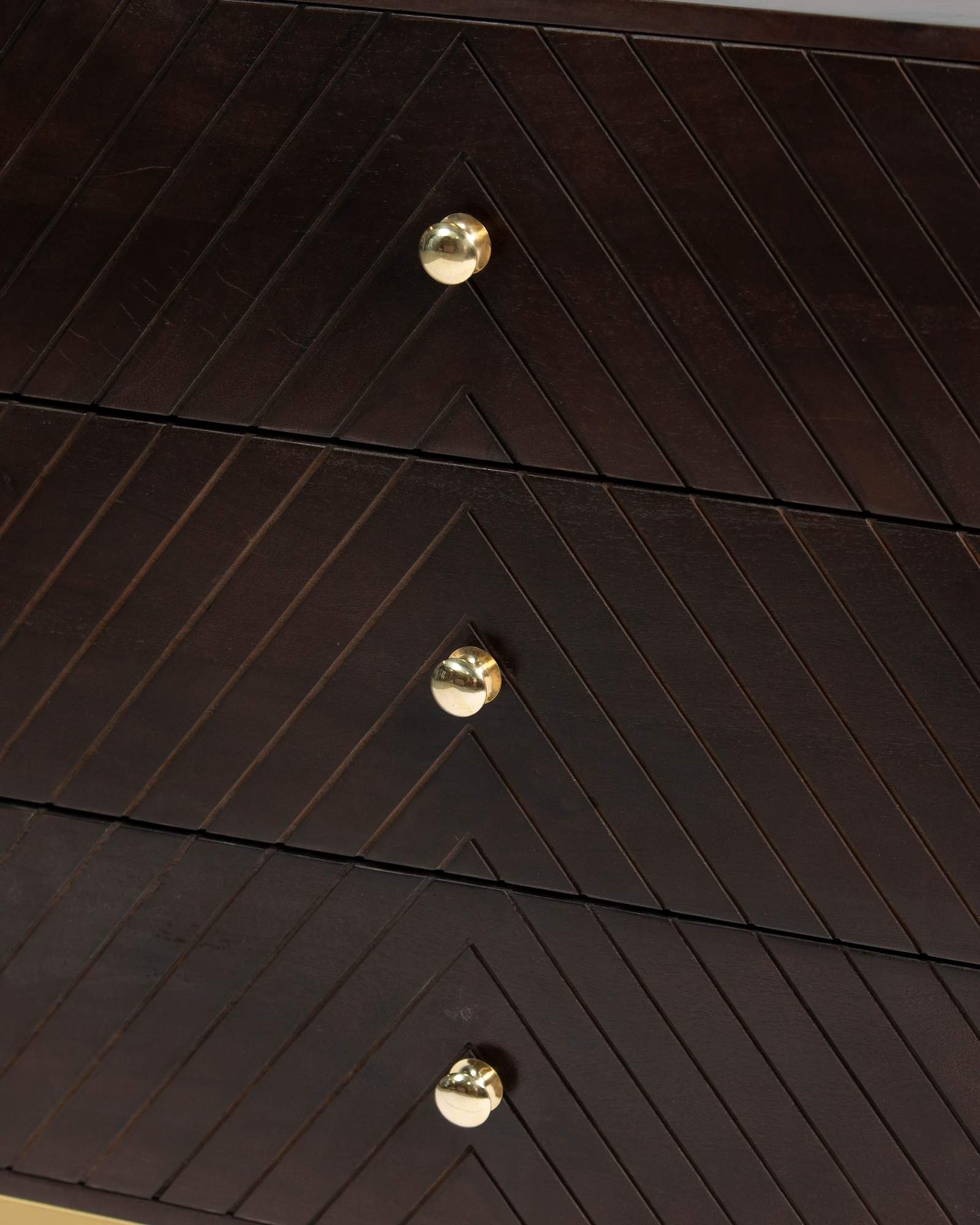 Wooden chest of drawers featuring chevron pattern in brown with brass accents, handcrafted furniture piece.