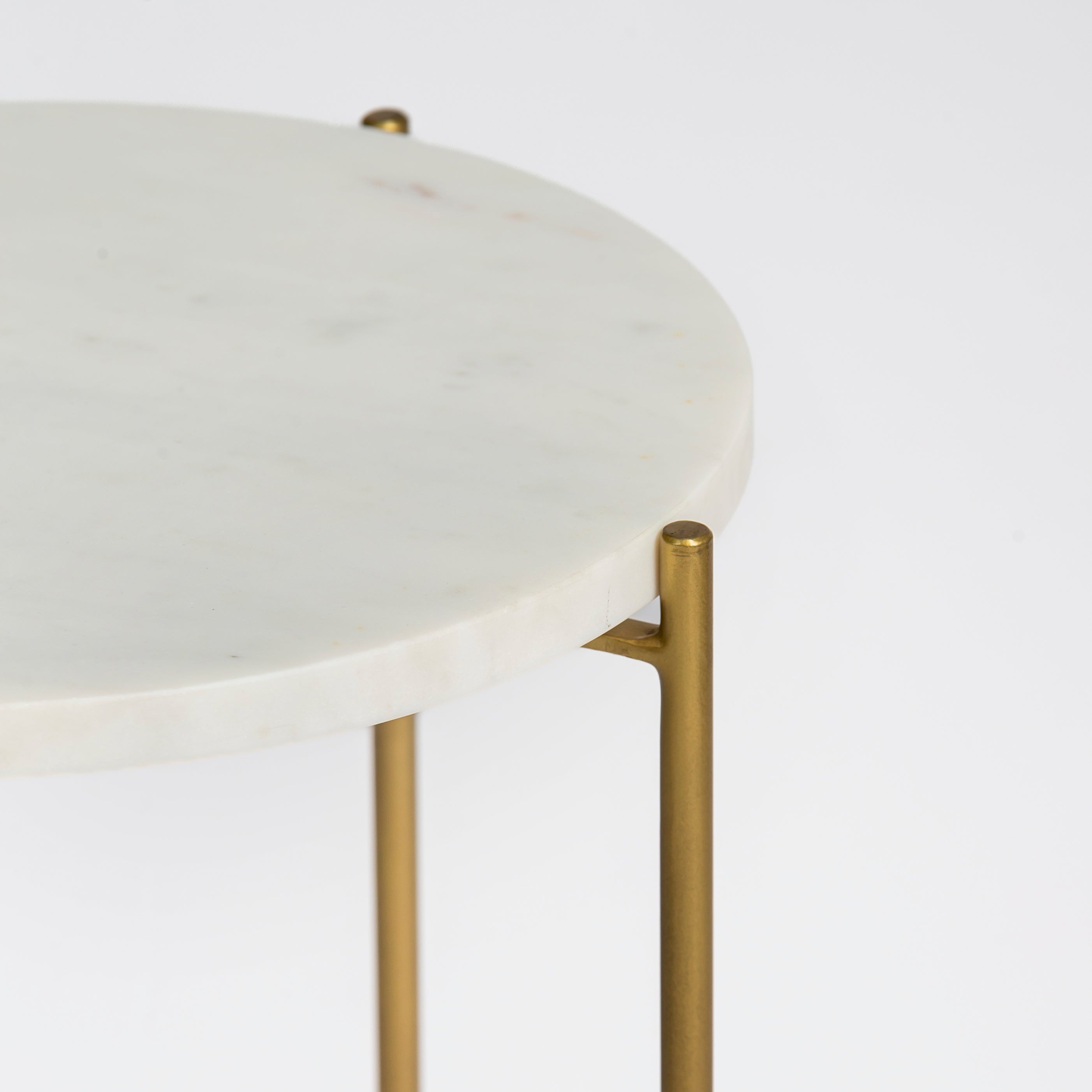 Marble side table featuring round white top with brass metal base, handcrafted furniture piece