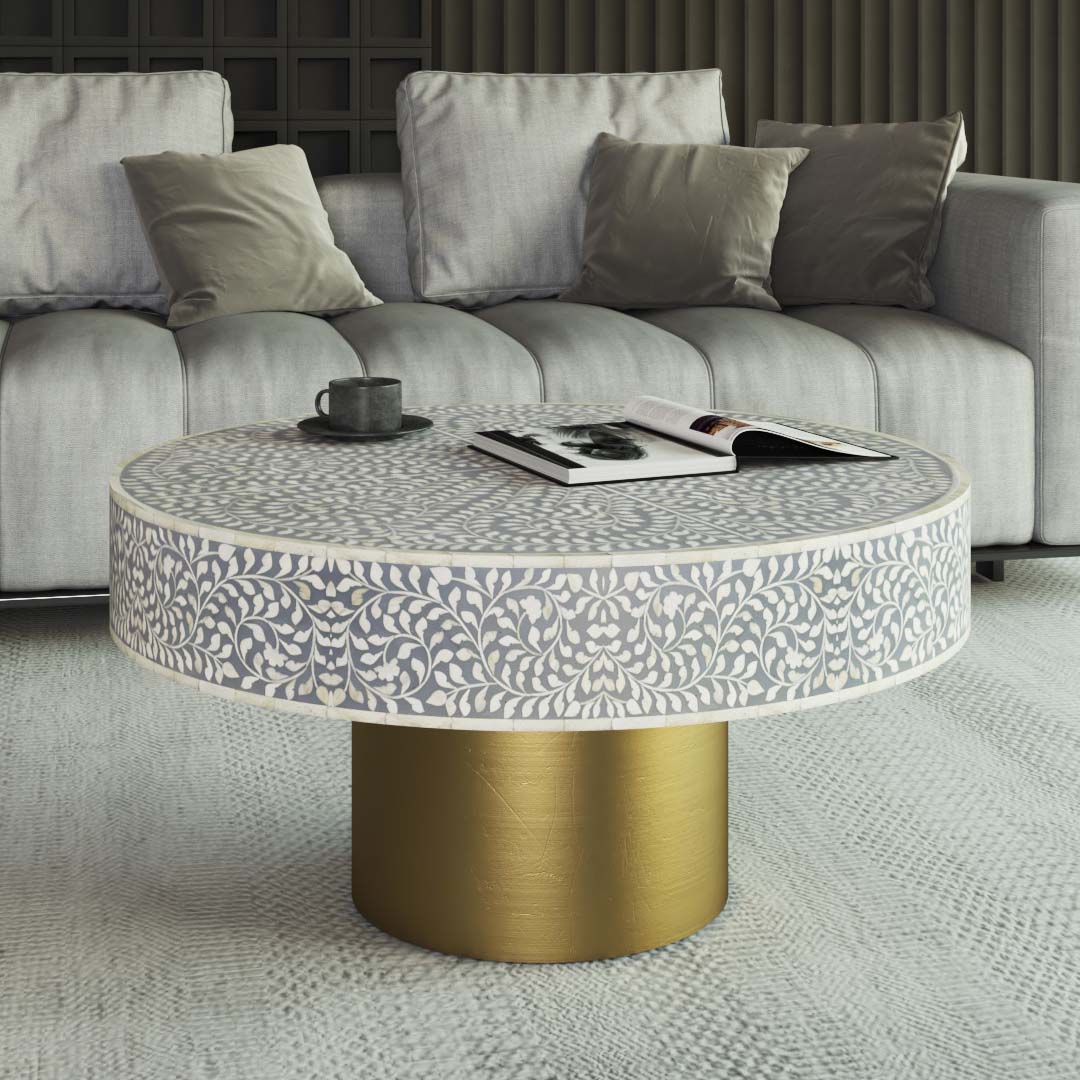 Round grey bone inlay coffee table featuring an intricate floral pattern and a bold gold base. Perfect for modern and elegant interiors.