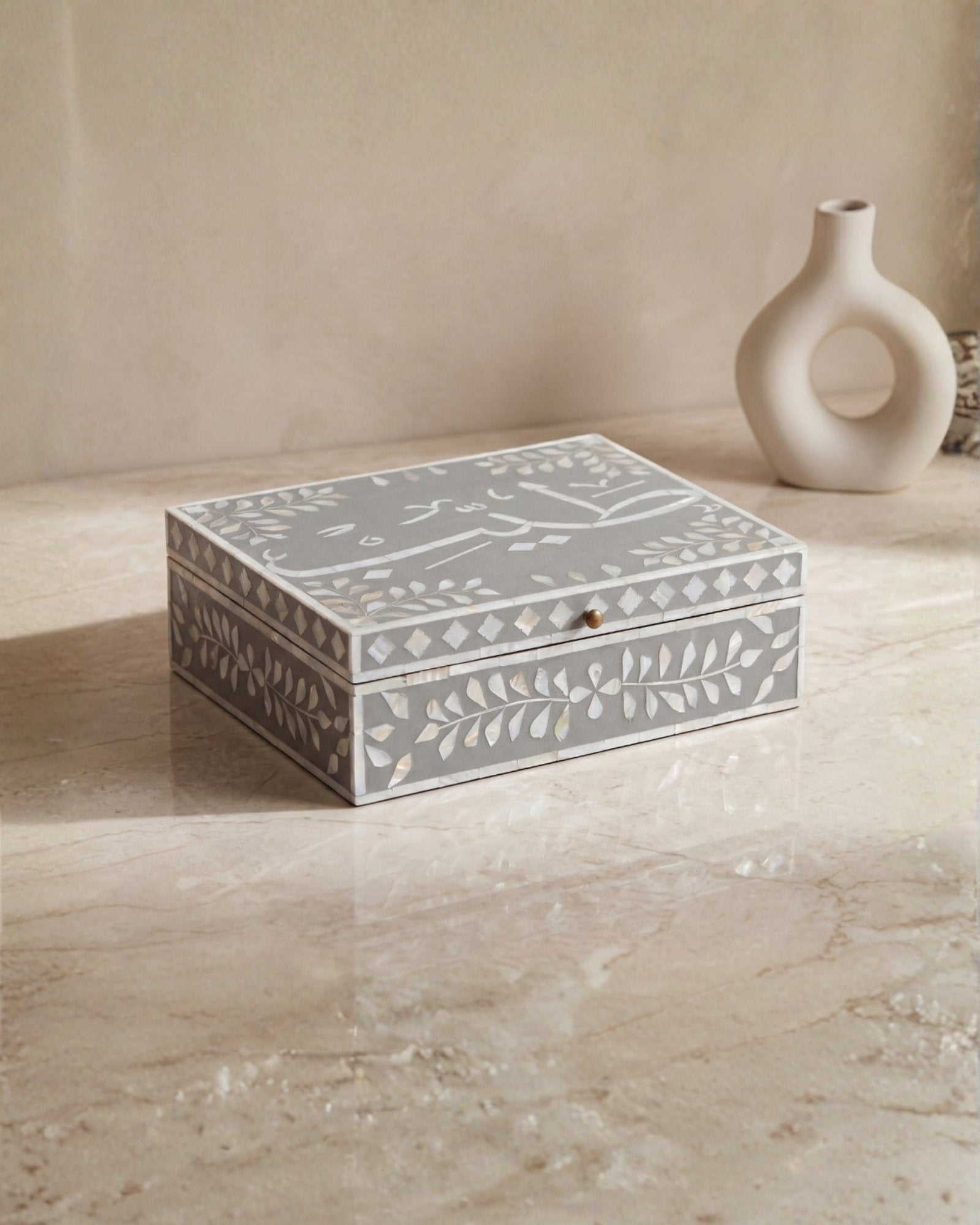 Mother of pearl inlay box featuring intricate floral pattern in grey and white, handcrafted decor piece.