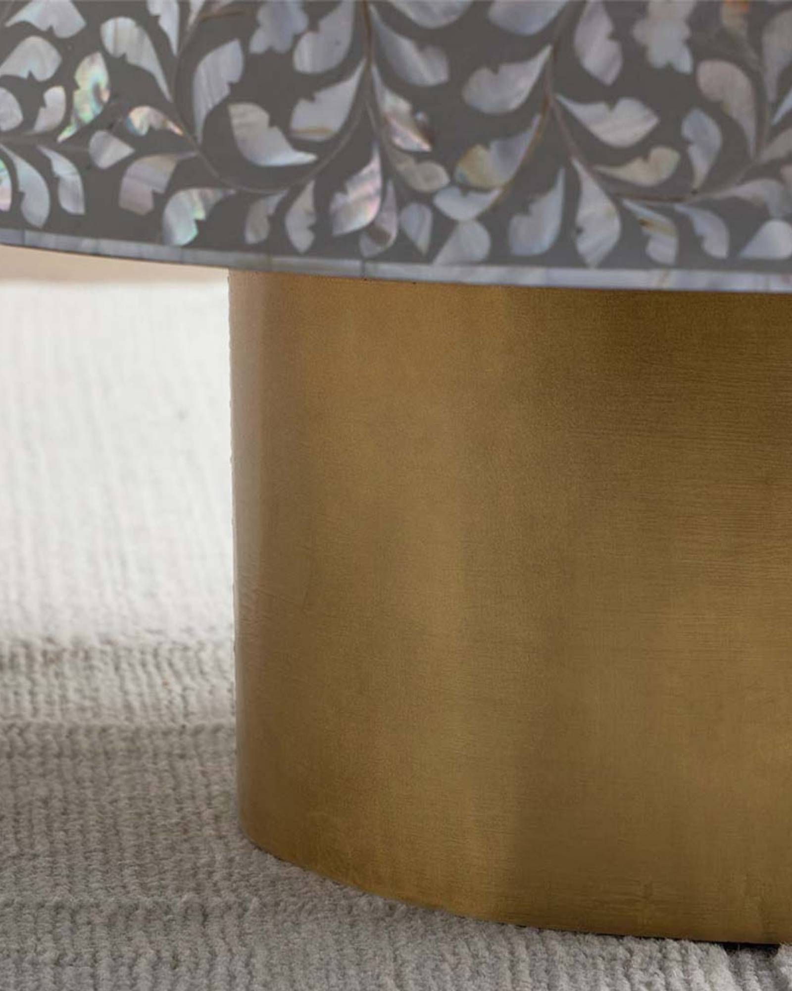 Round grey mother of pearl inlay coffee table with intricate floral design and a gold cylindrical metallic base.