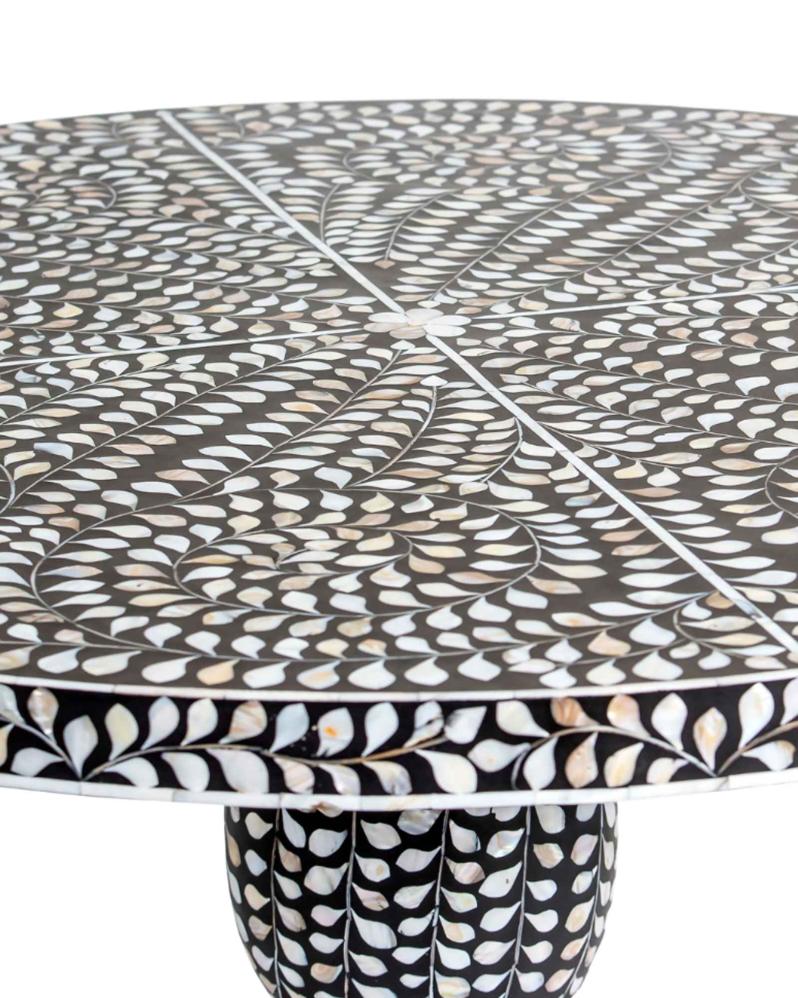 Handcrafted Iris dining table featuring black mother of pearl inlay with a round top and sculptural pedestal base.