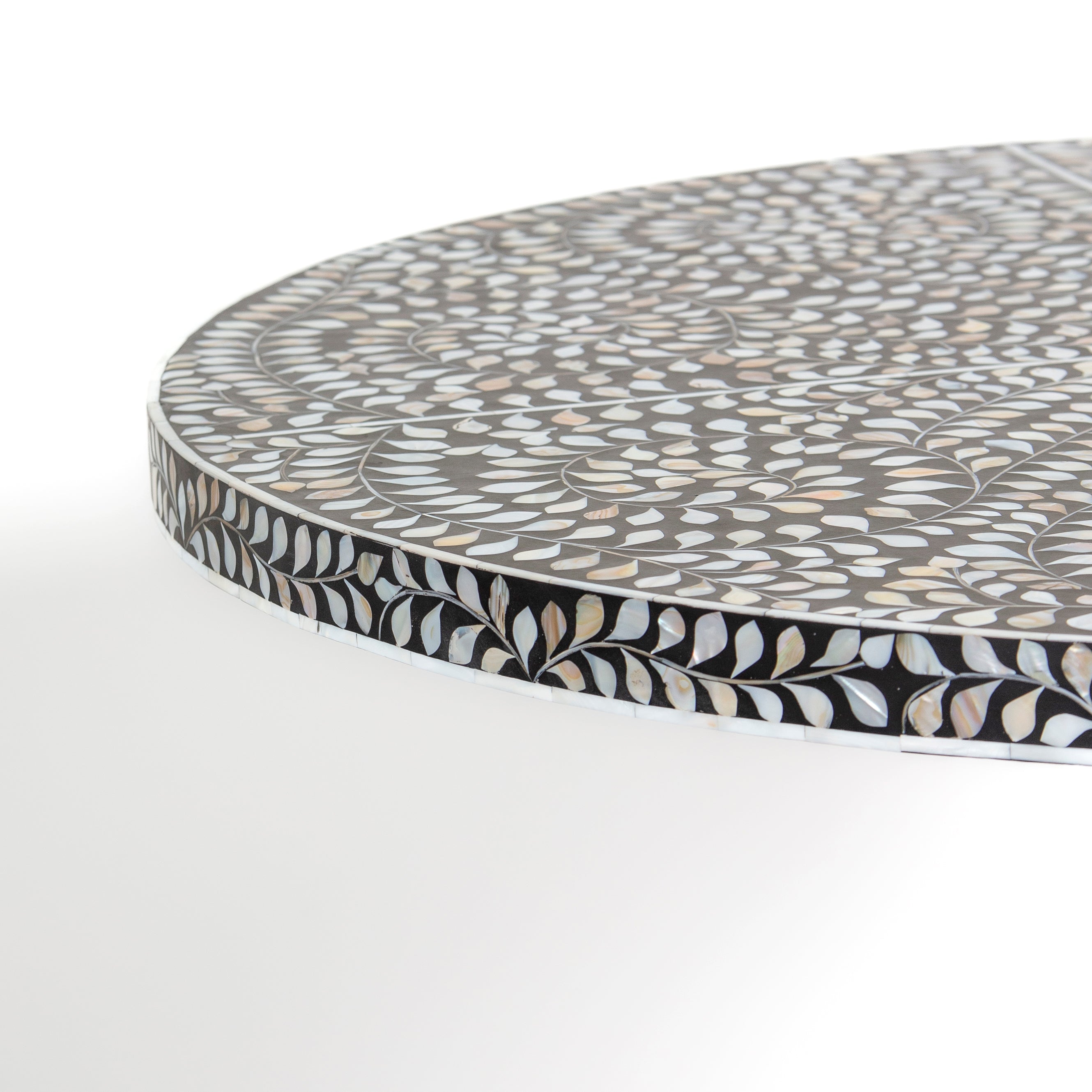 Handcrafted Iris dining table featuring black mother of pearl inlay with a round top and sculptural pedestal base.